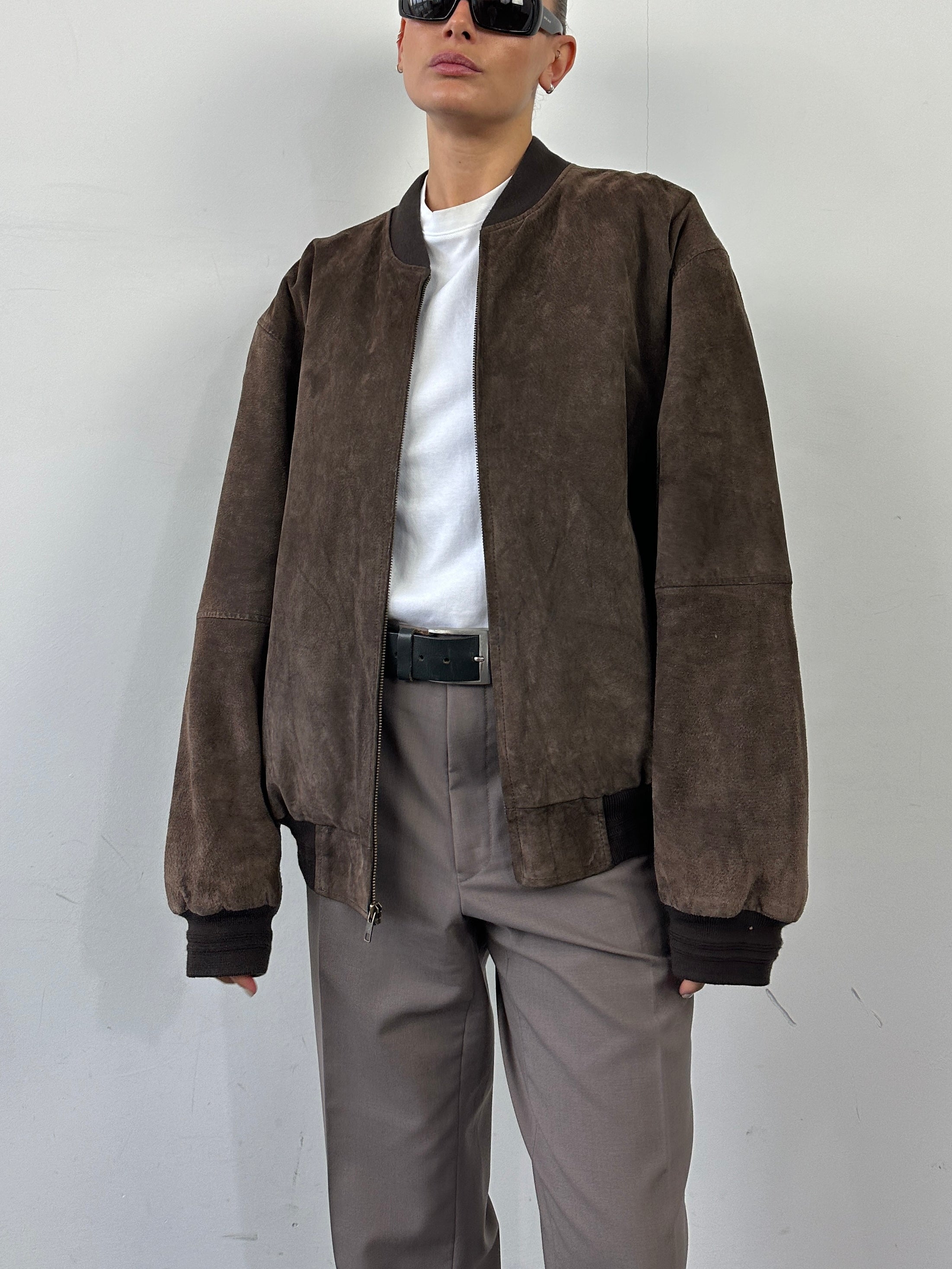 Vintage brand XL vintage suede leather bomber jacket with classic design and ribbed cuffs, displayed on a hanger.