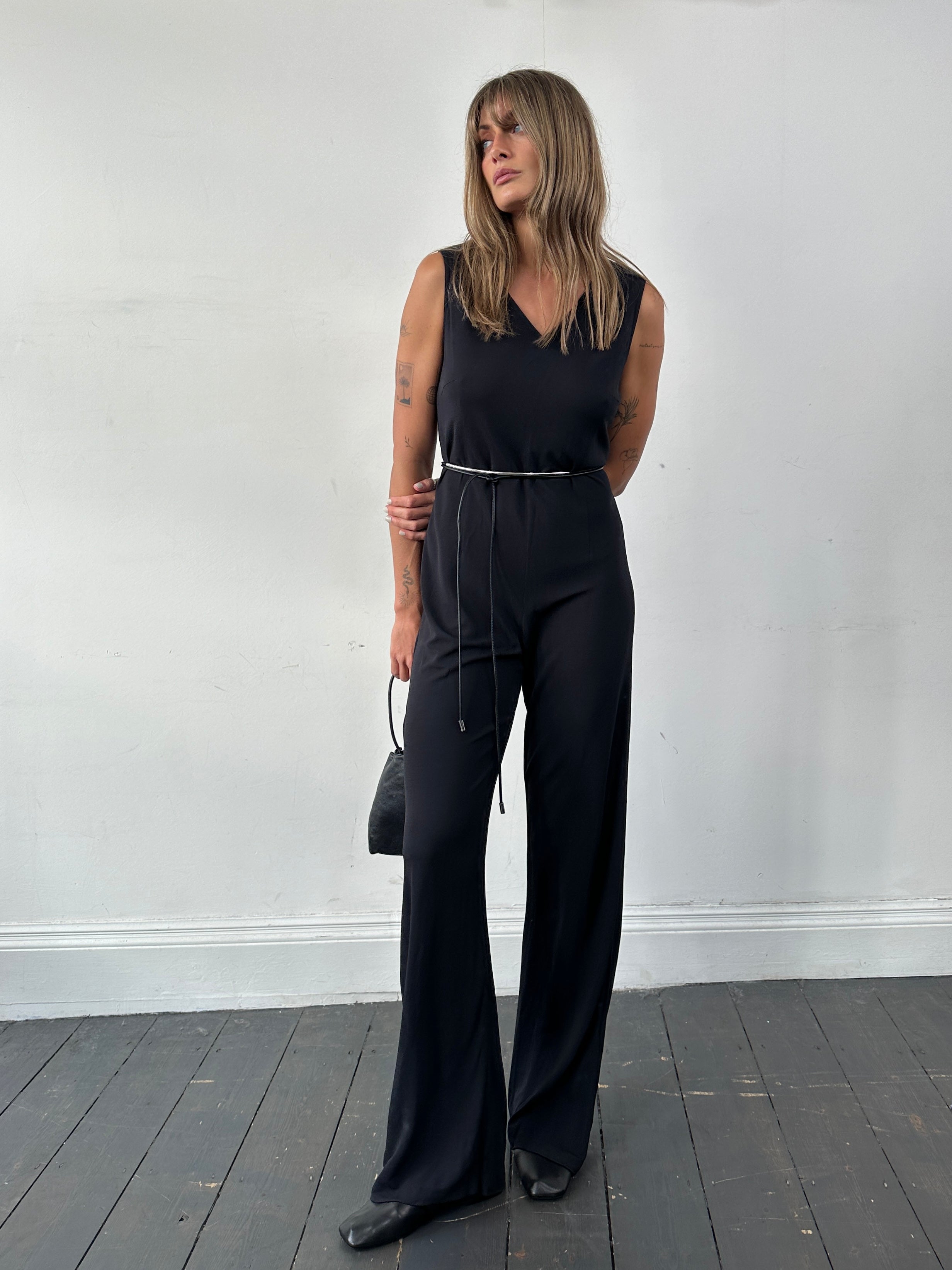 Vintage 80s V neck stretch jumpsuit in S/M size, featuring a fitted silhouette and retro style, displayed on a hanger.