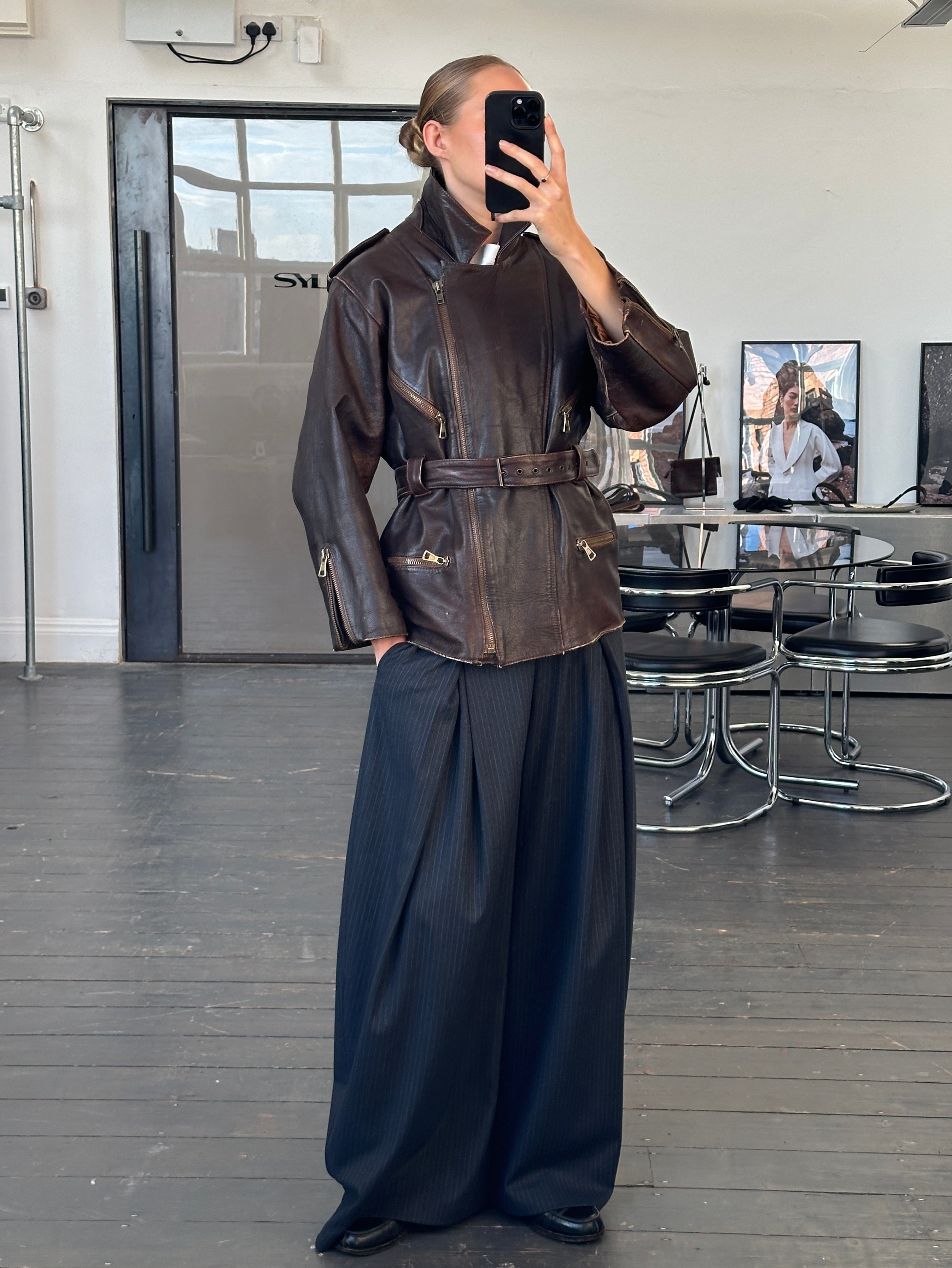 Vintage Italian 1990s belted leather jacket, aged brown leather, with classic design and metal buckle details.