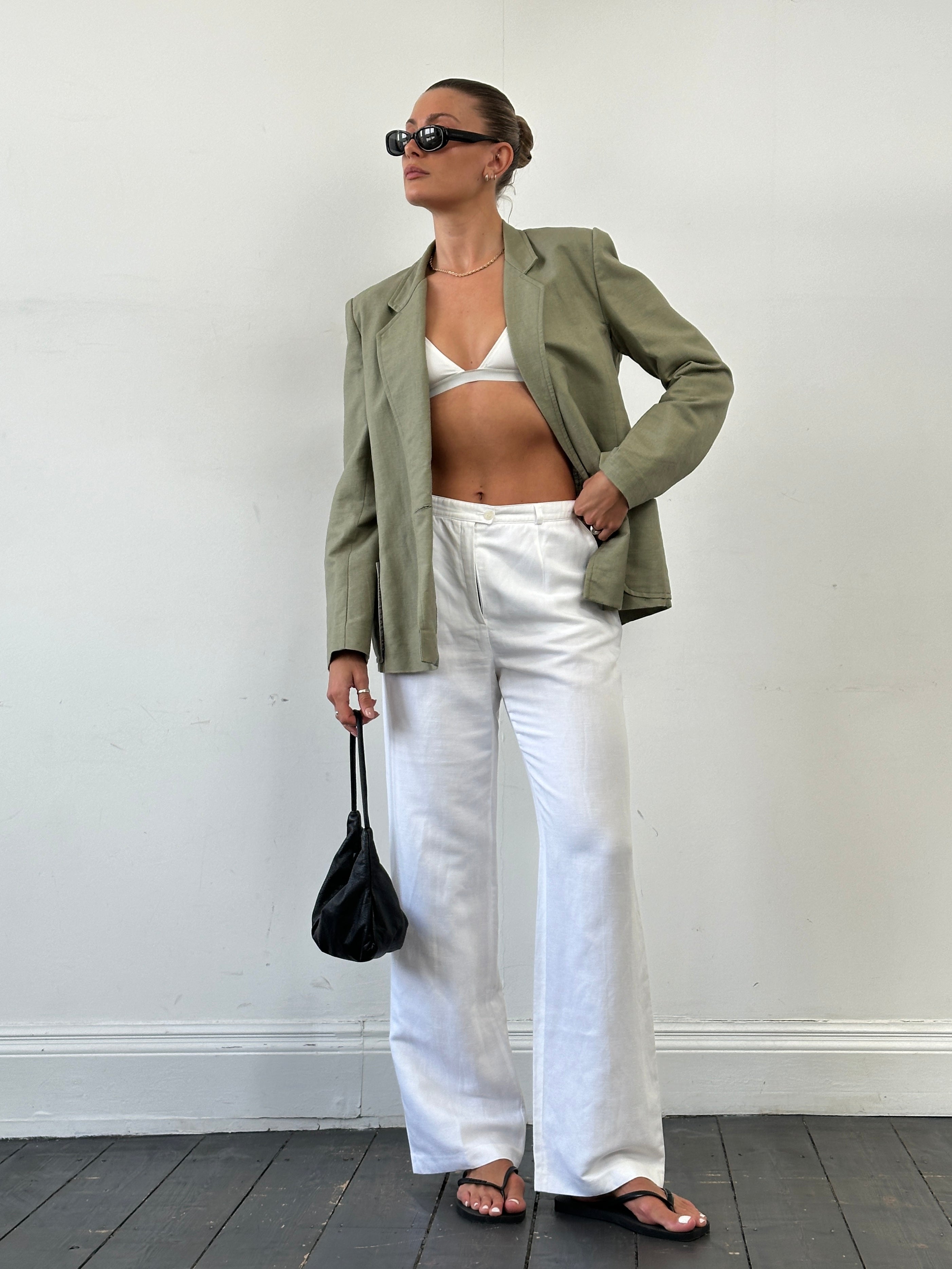 Vintage linen straight-leg high-waisted trousers in natural color, displayed on a hanger with a focus on fit and fabric texture.