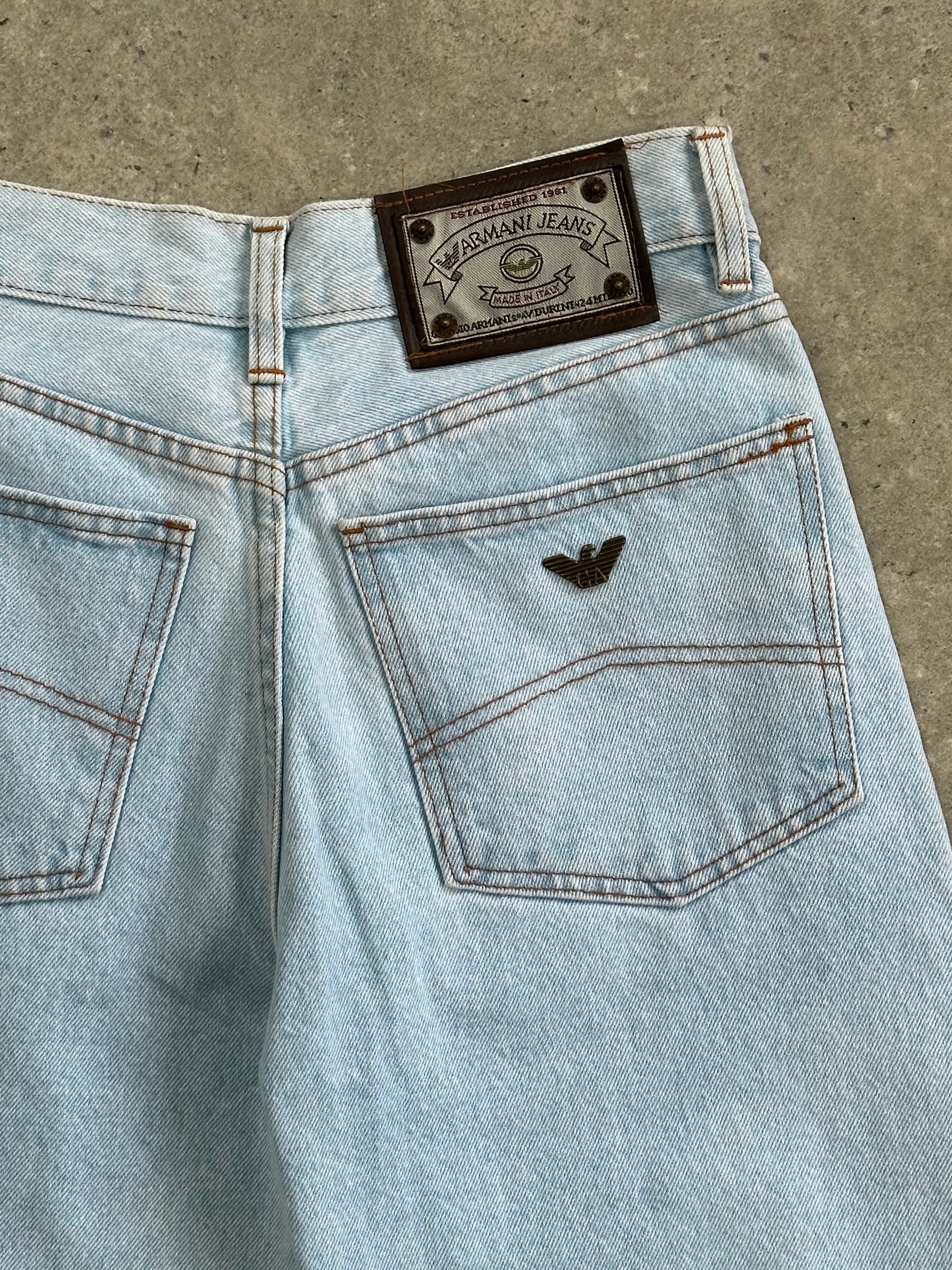 Armani Jeans light wash tapered leg denim jeans with W26 waist, showcasing classic five-pocket design and slim fit style.