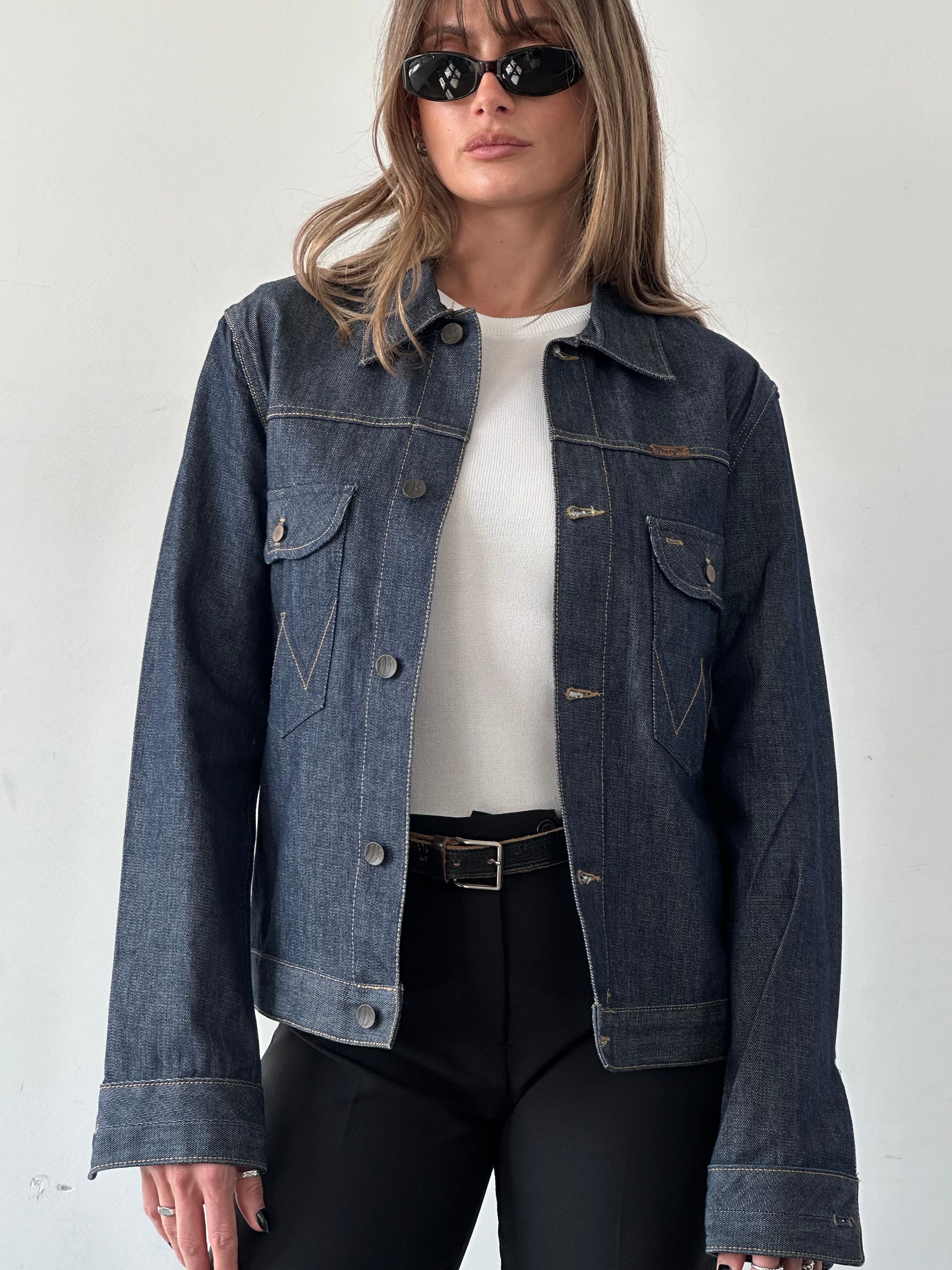 Wrangler organic cotton denim jacket in size S/M displayed on a hanger with classic blue denim fabric and metal button details.