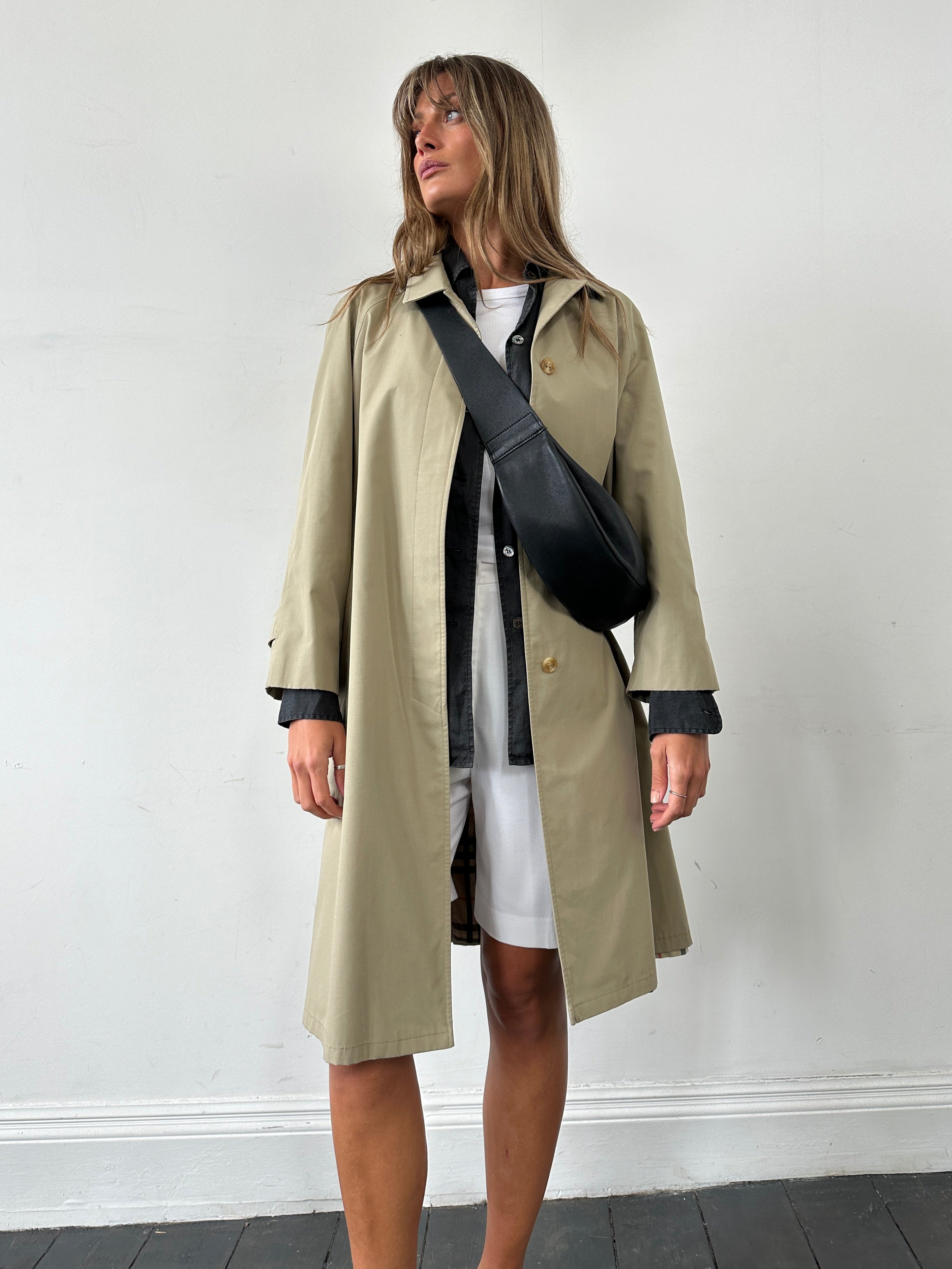 Vintage showerproof belted trench coat in size M, featuring classic design and durable fabric, perfect for rainy weather.
