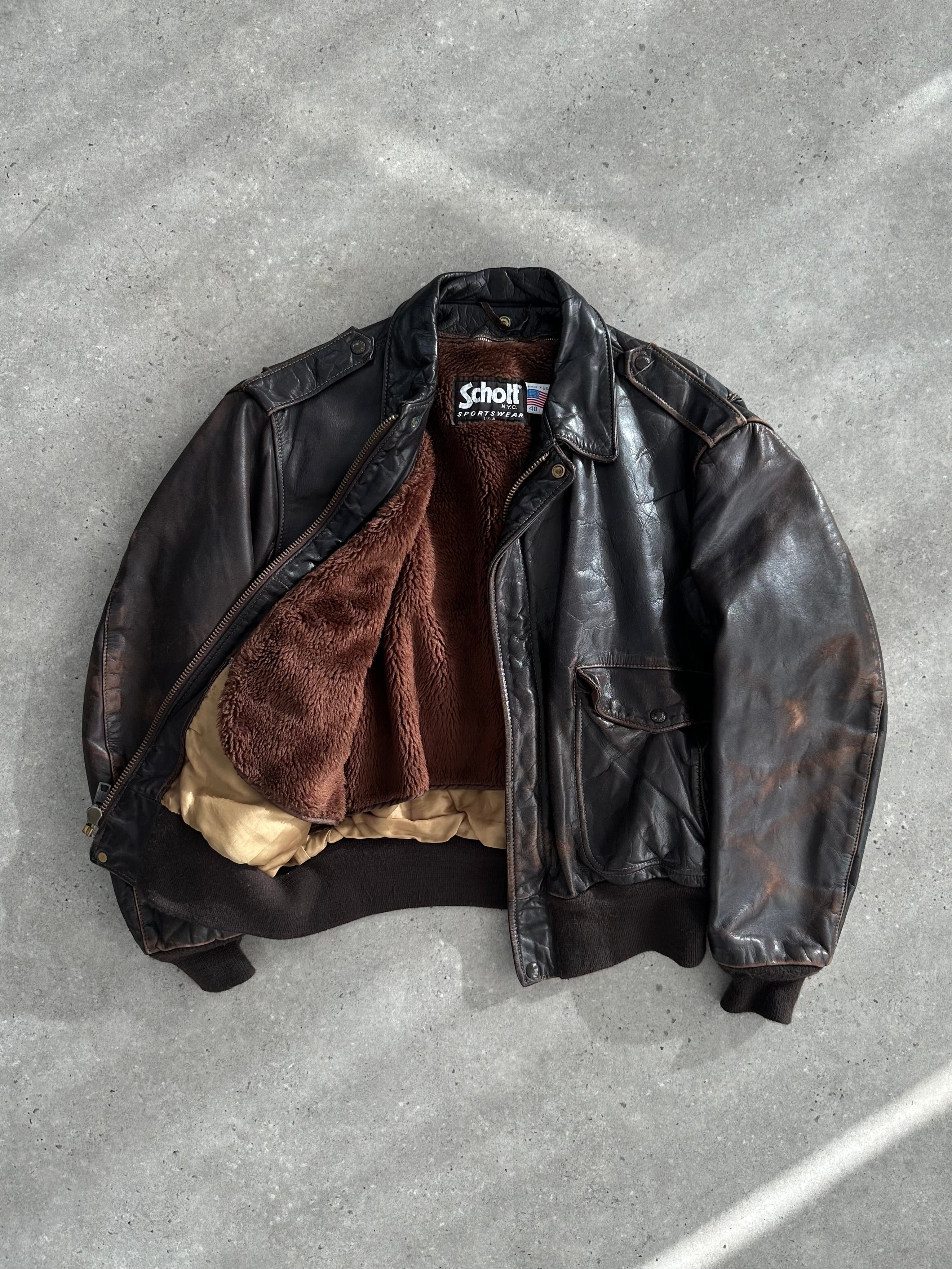 Schott NYC distressed leather bomber jacket in size L/XL with a rugged, vintage look and classic design.