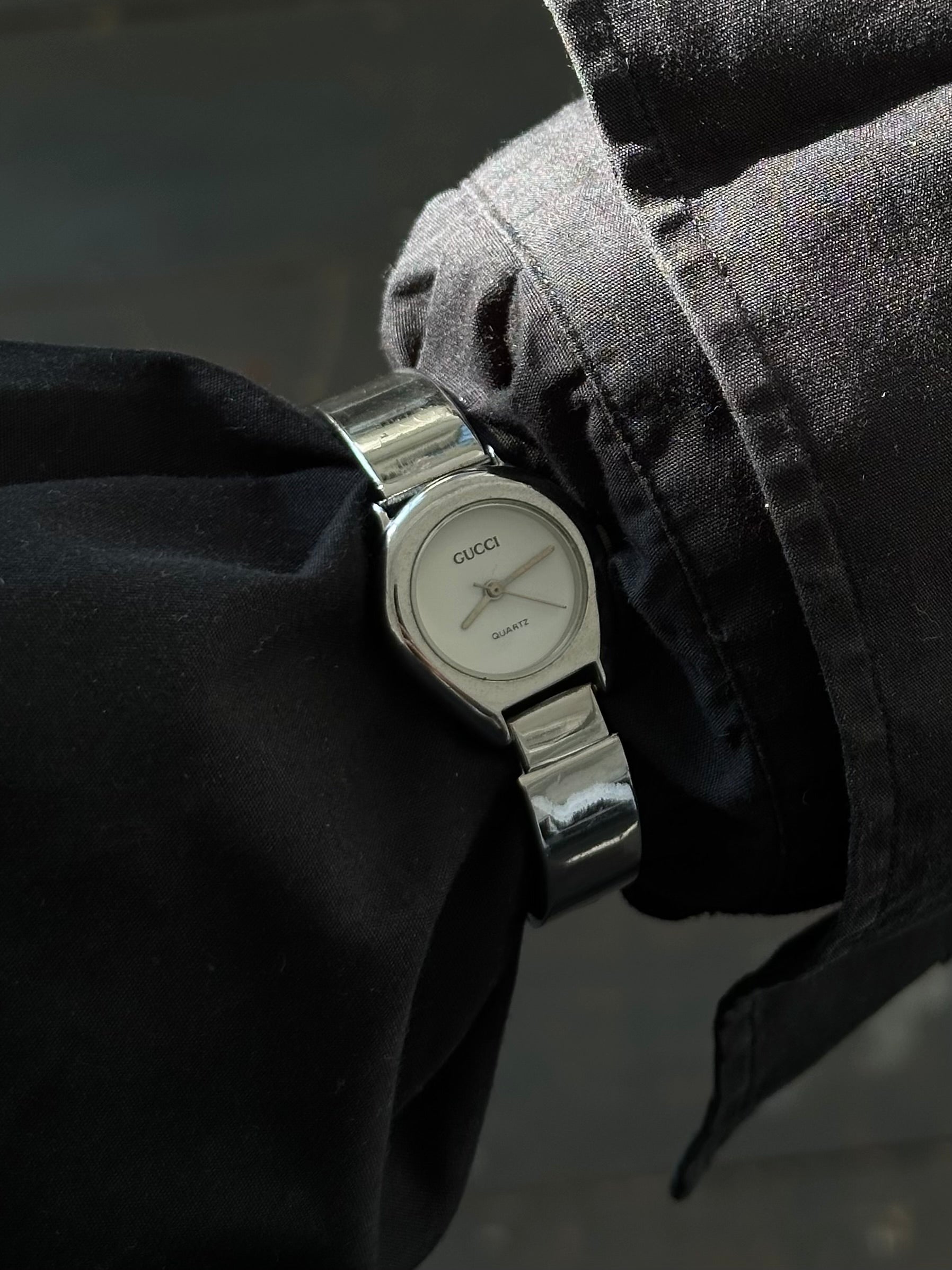 Gucci 1990s stainless steel quartz watch with sleek round face and metal band, classic and stylish timepiece.
