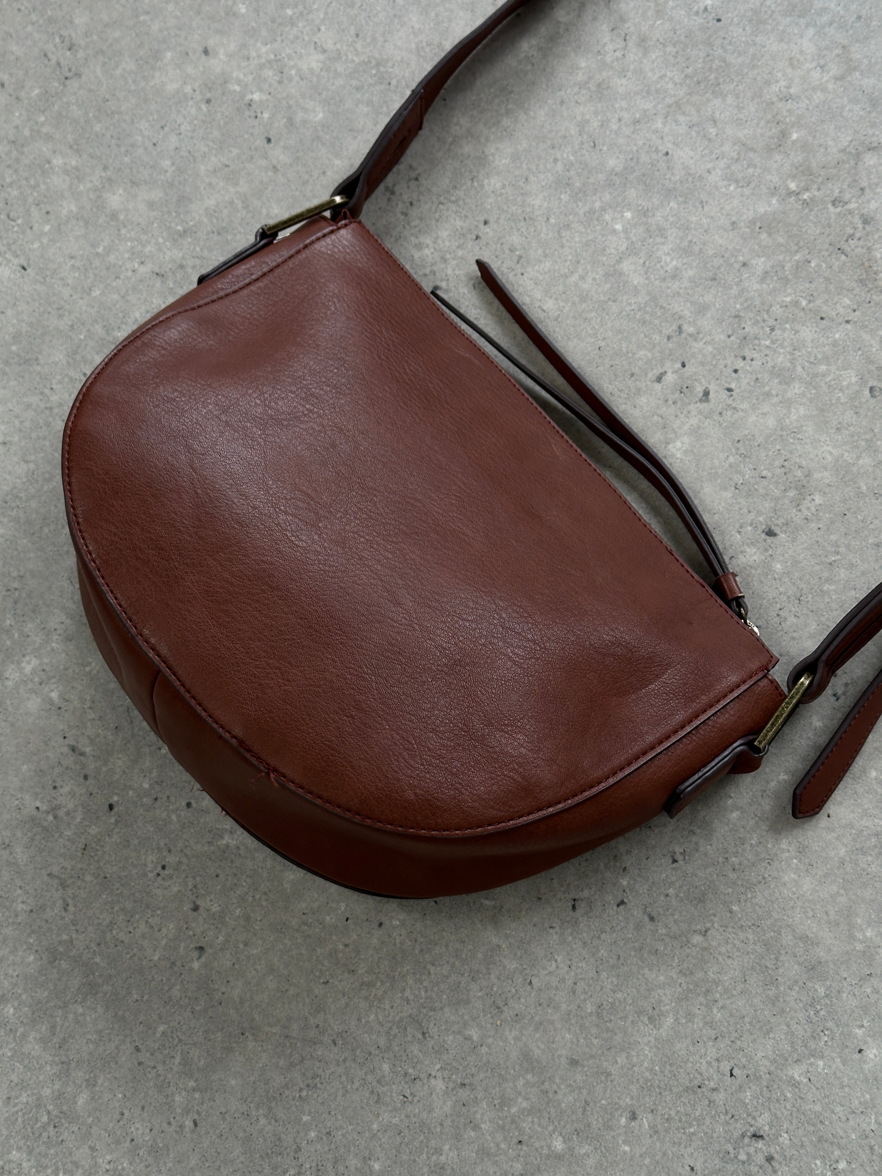Vintage faux leather crescent crossbody bag with adjustable strap and minimalist design, perfect for casual or stylish outings.