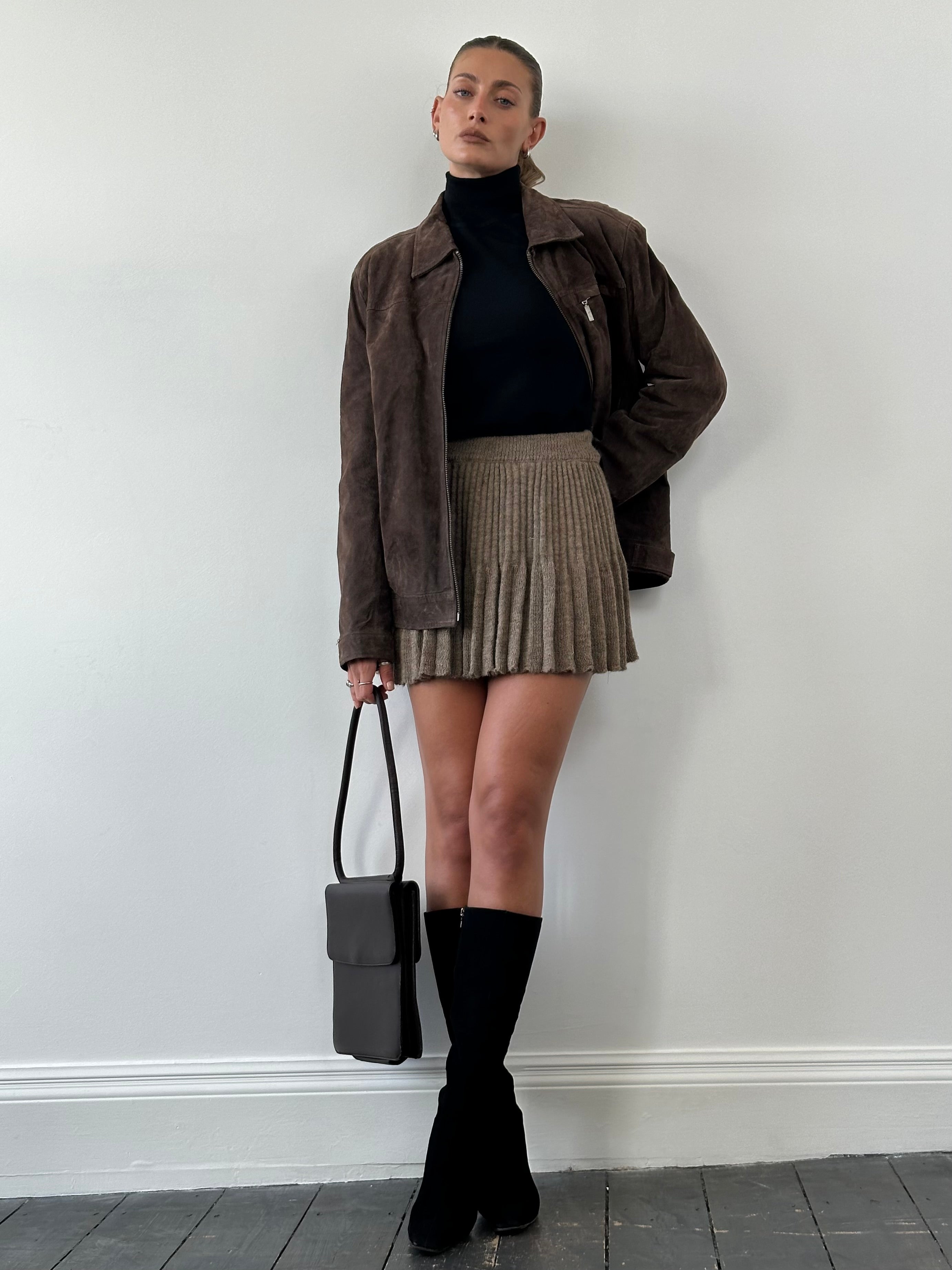 Vintage Italian mohair blend pleated skirt in S/M displayed on a hanger, showcasing its soft fabric and classic pleated design.