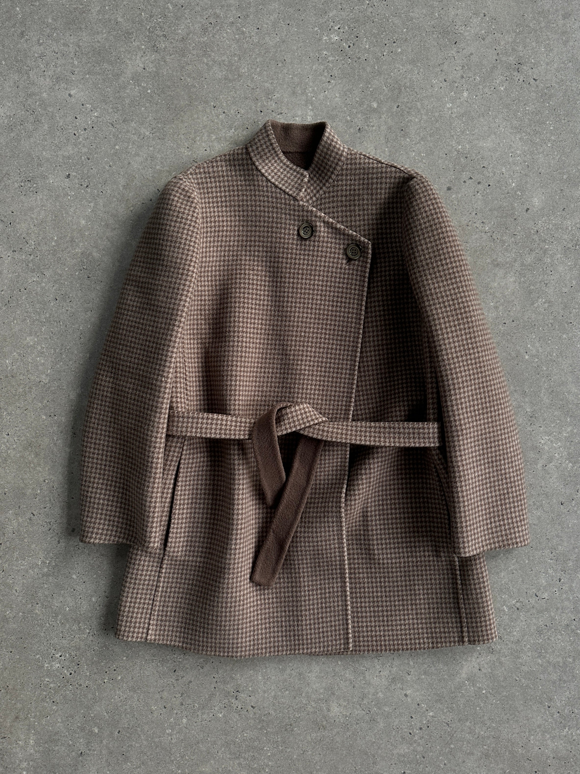 Vintage Italian vintage wool reversible belted coat hanging on a wooden rack, showcasing its classic design and neutral tones.