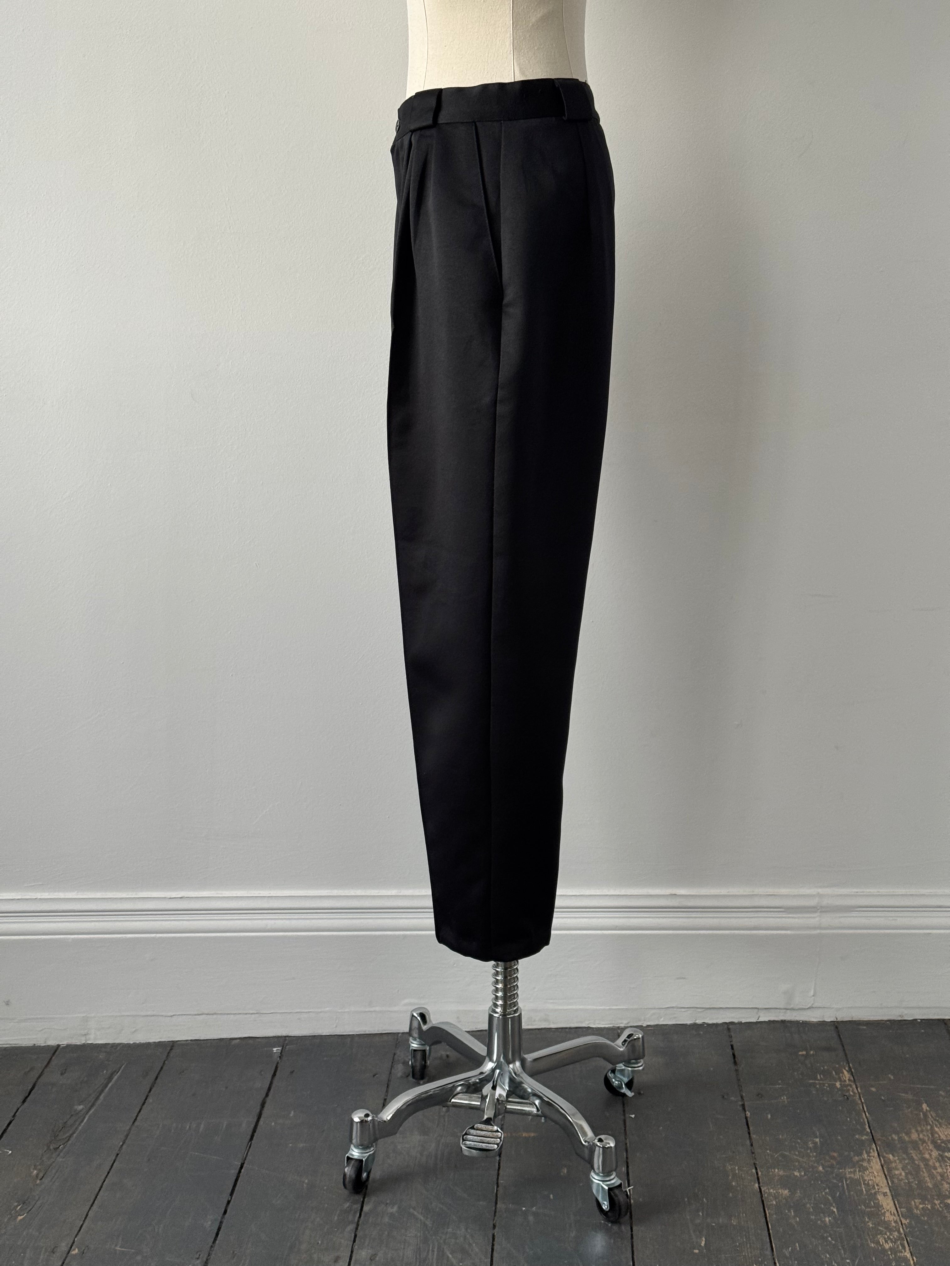Vintage 1980s satin tapered leg high-waisted trousers in dark color, displayed on a hanger.