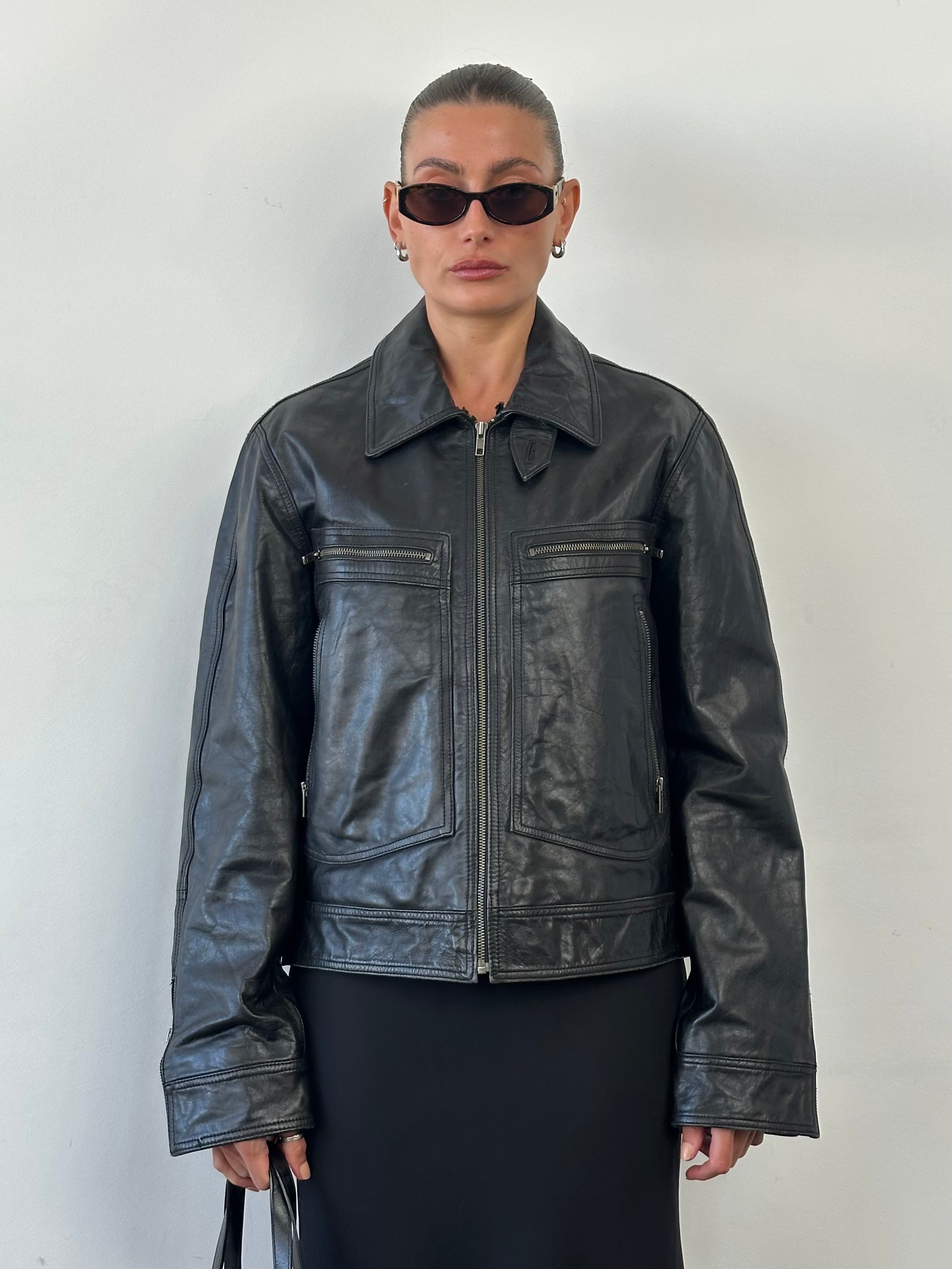 Conbipel high neck leather jacket in black, featuring a sleek design and high collar, displayed on a hanger.