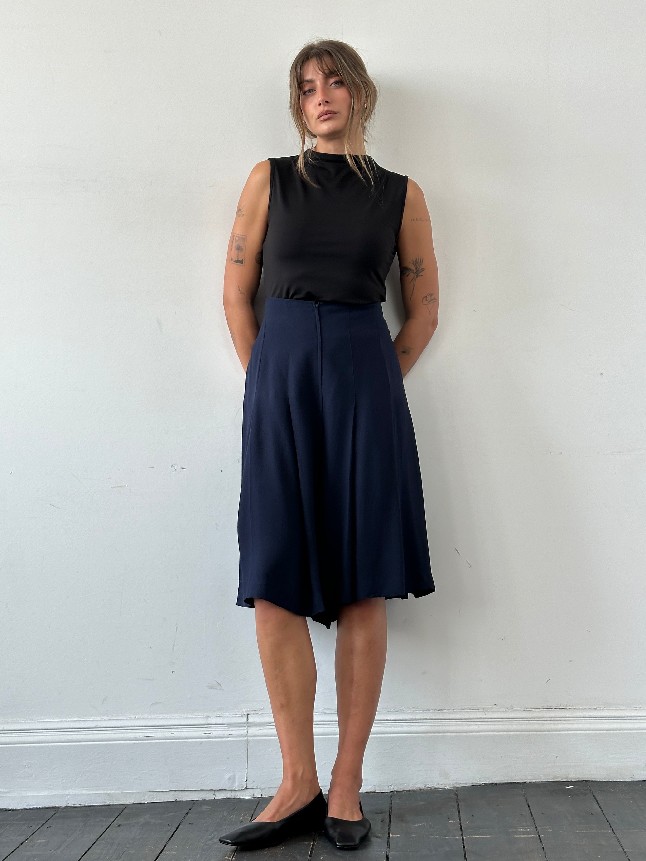 Valentino boutique high-waisted pleated culottes in short style, featuring wide legs and W32 size, displayed on a hanger.