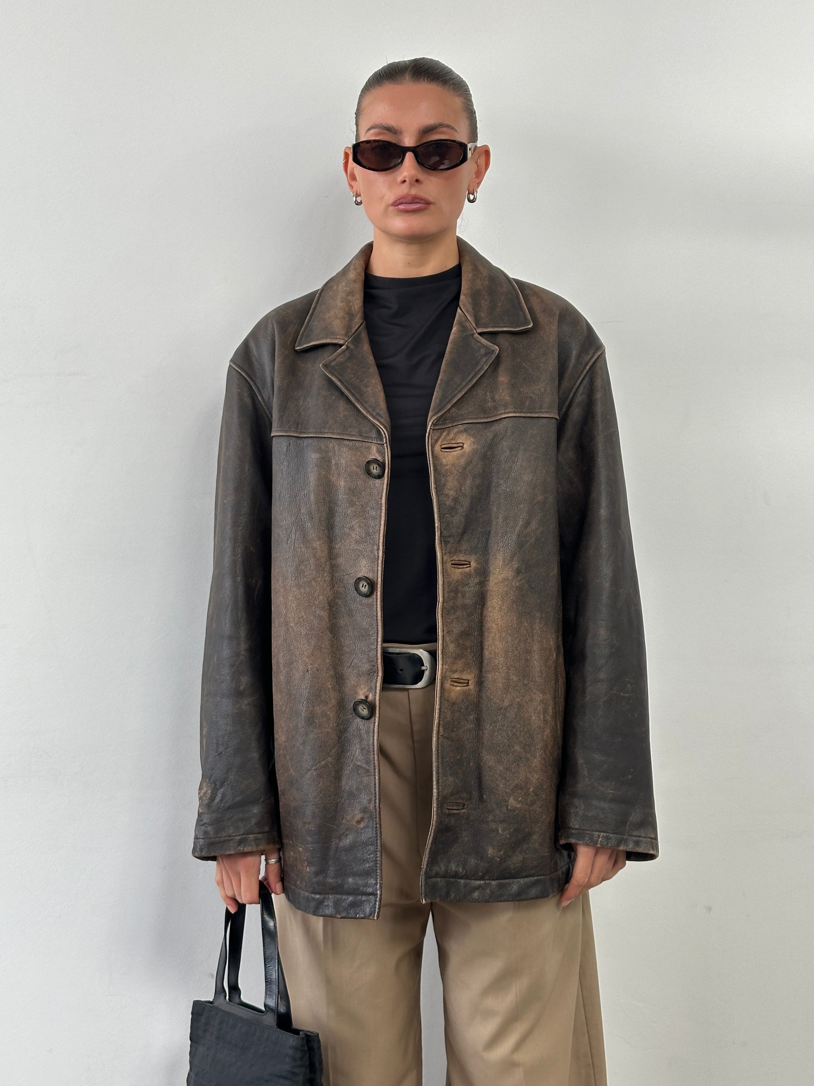 Guess distressed leather jacket in size XL, featuring a rugged design with visible stitching and a classic collar.