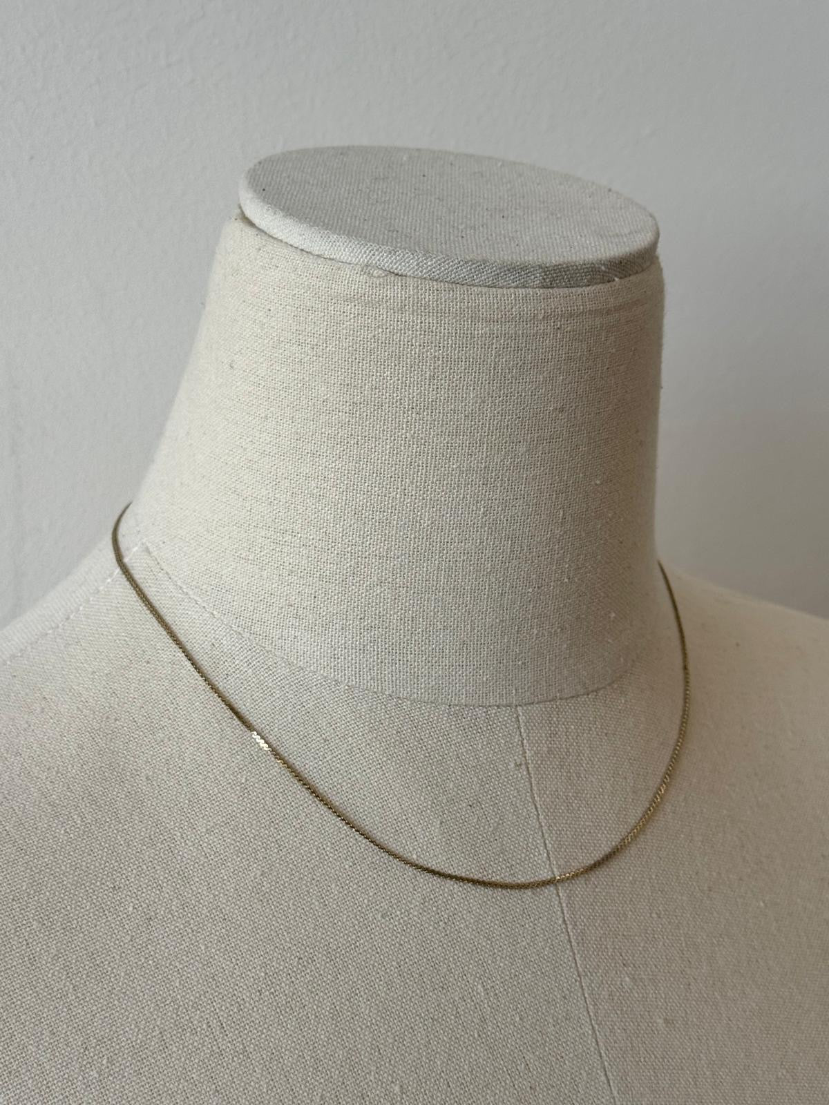 Pierre Cardin 1990s gold plated necklace with fine chain and elegant design, shown close-up in the image.