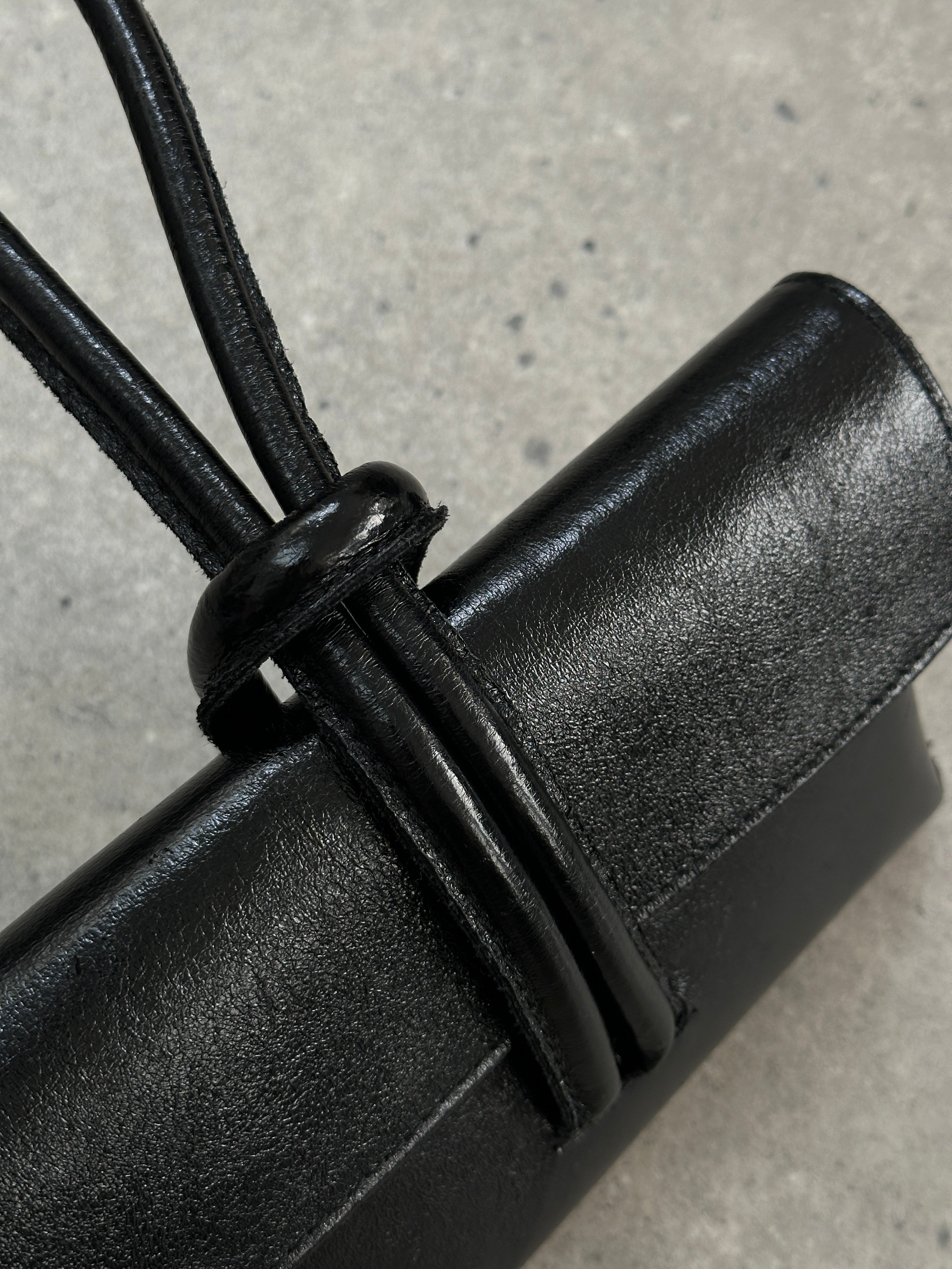 Italian vintage leather crossbody clutch bag with classic design, featuring a sleek, compact form and rich leather texture.