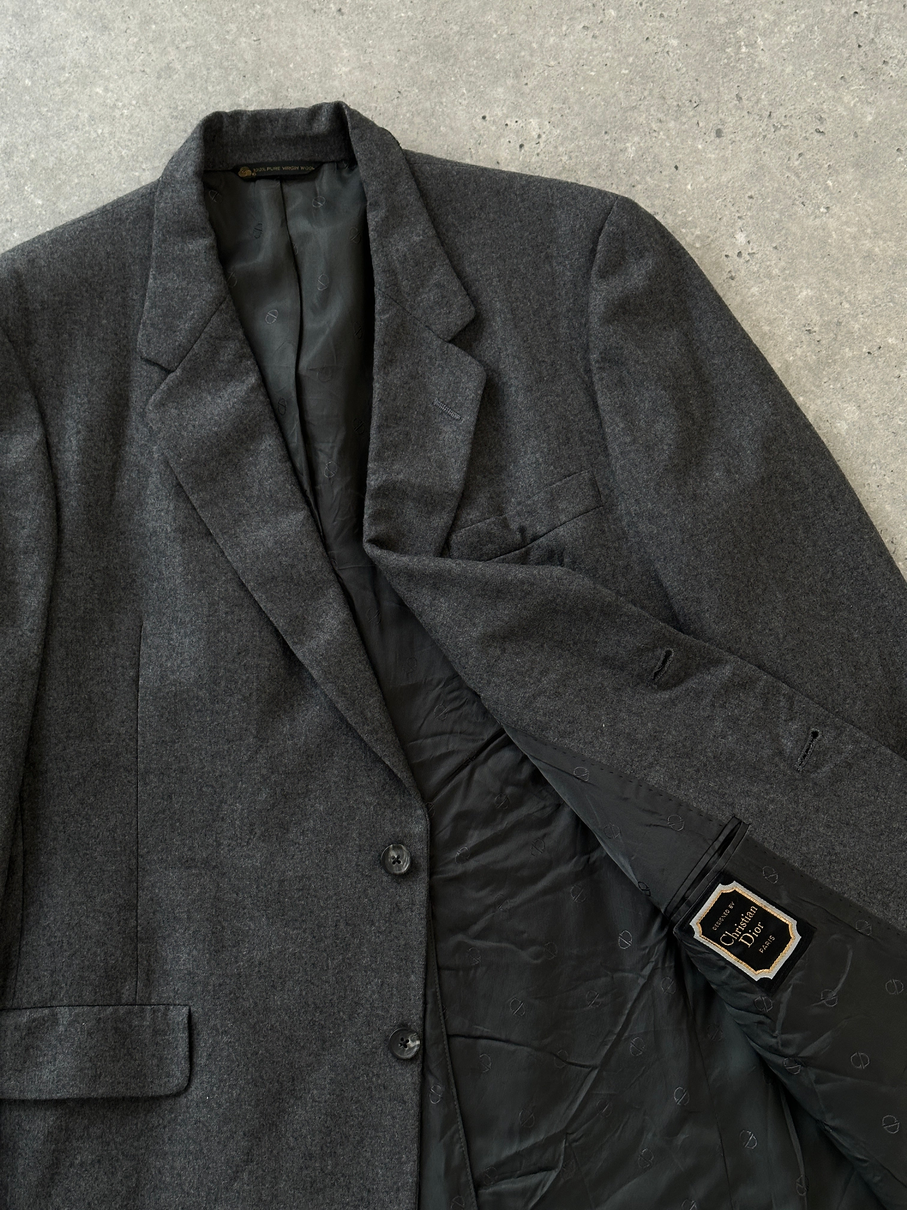 Christian Dior pure wool blazer in size L, tailored fit with classic lapel and button closure, shown on a hanger.