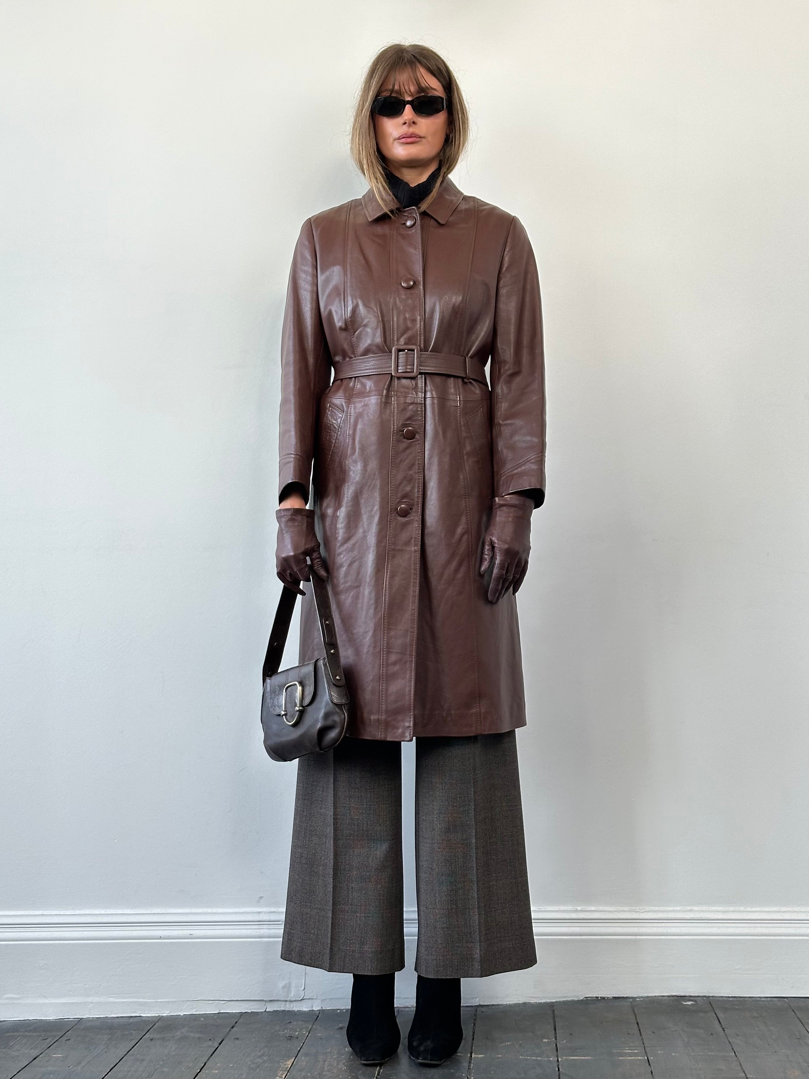Vintage leather belted trench coat jacket in classic style, featuring smooth leather and a tailored fit for a timeless look.