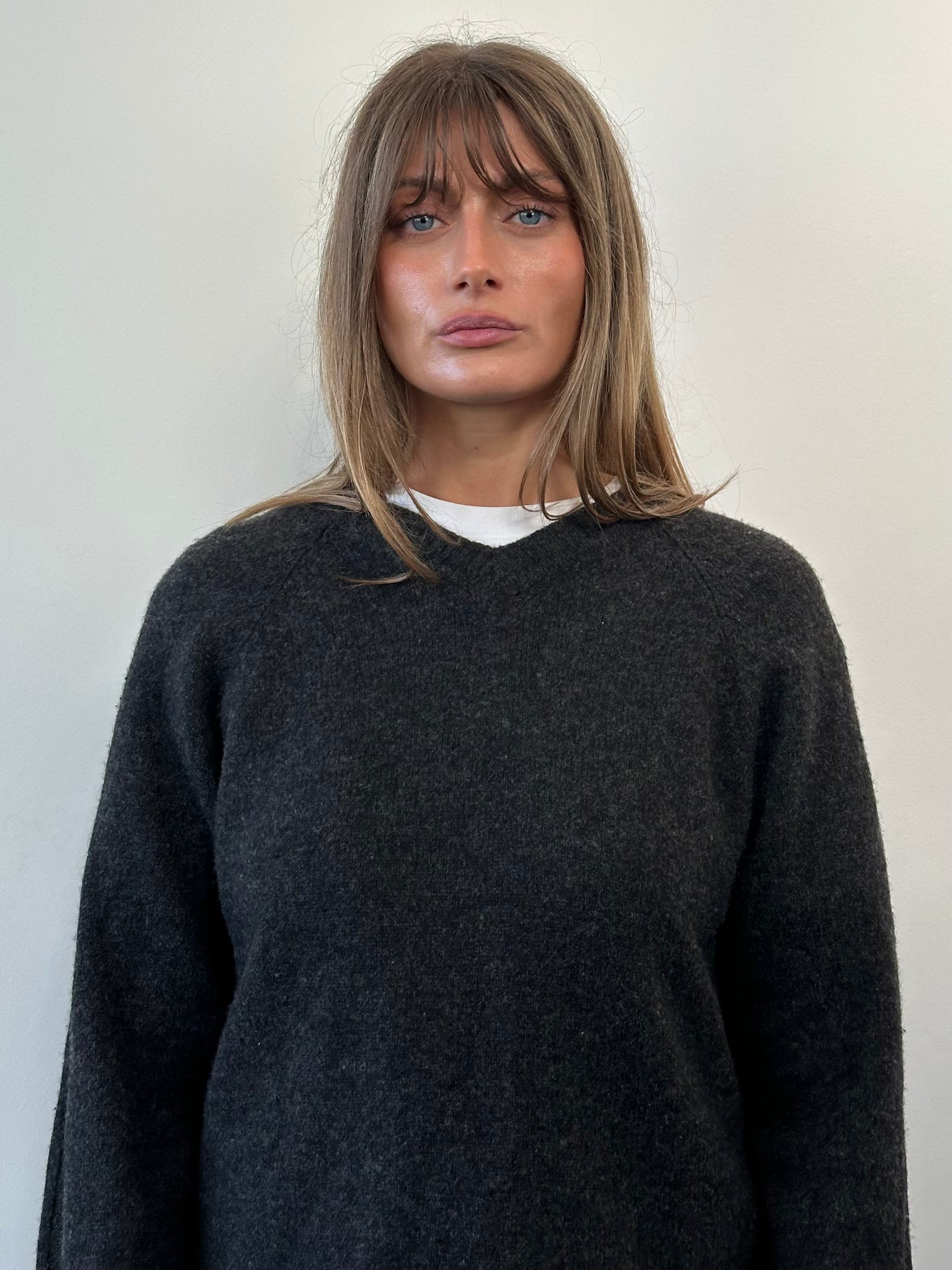 Armani Jeans wool V-neck jumper in size M/L, featuring a classic knit design and ribbed collar, displayed on a neutral background.