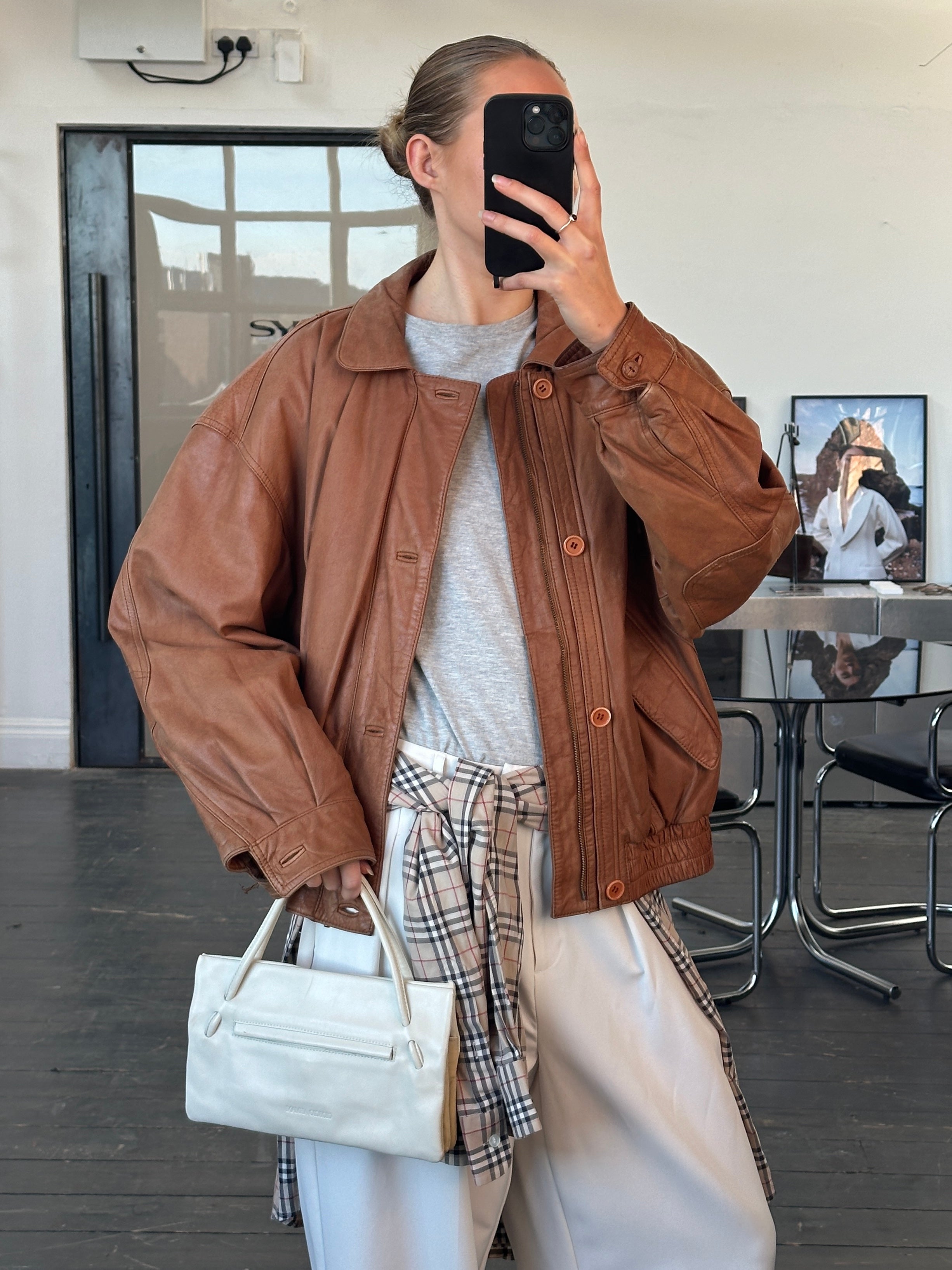 Vintage 1980s leather bomber jacket in size L, featuring classic design and worn leather texture.