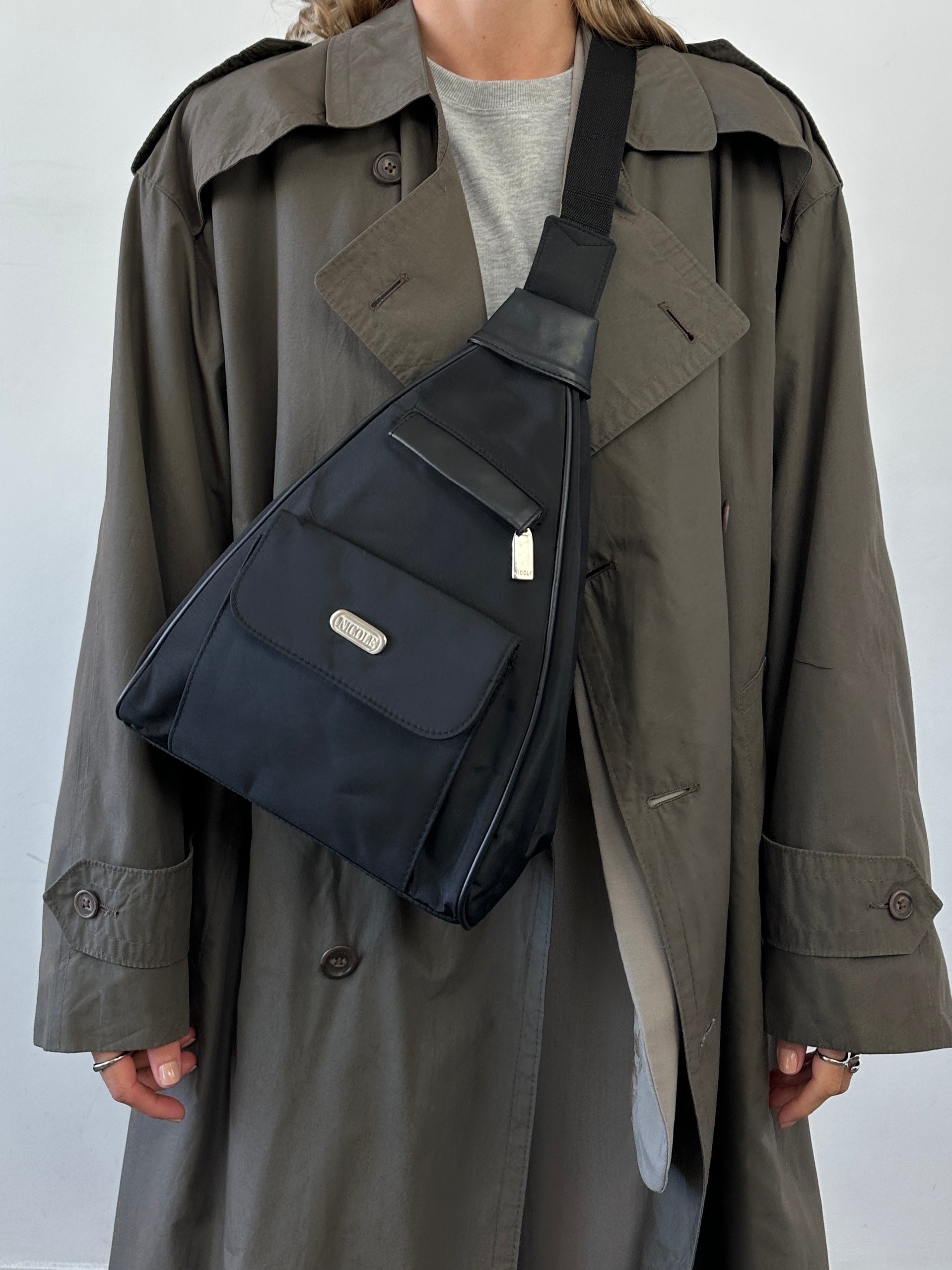 Vintage sling bag with adjustable strap and classic design, featuring durable fabric and stylish detailing.