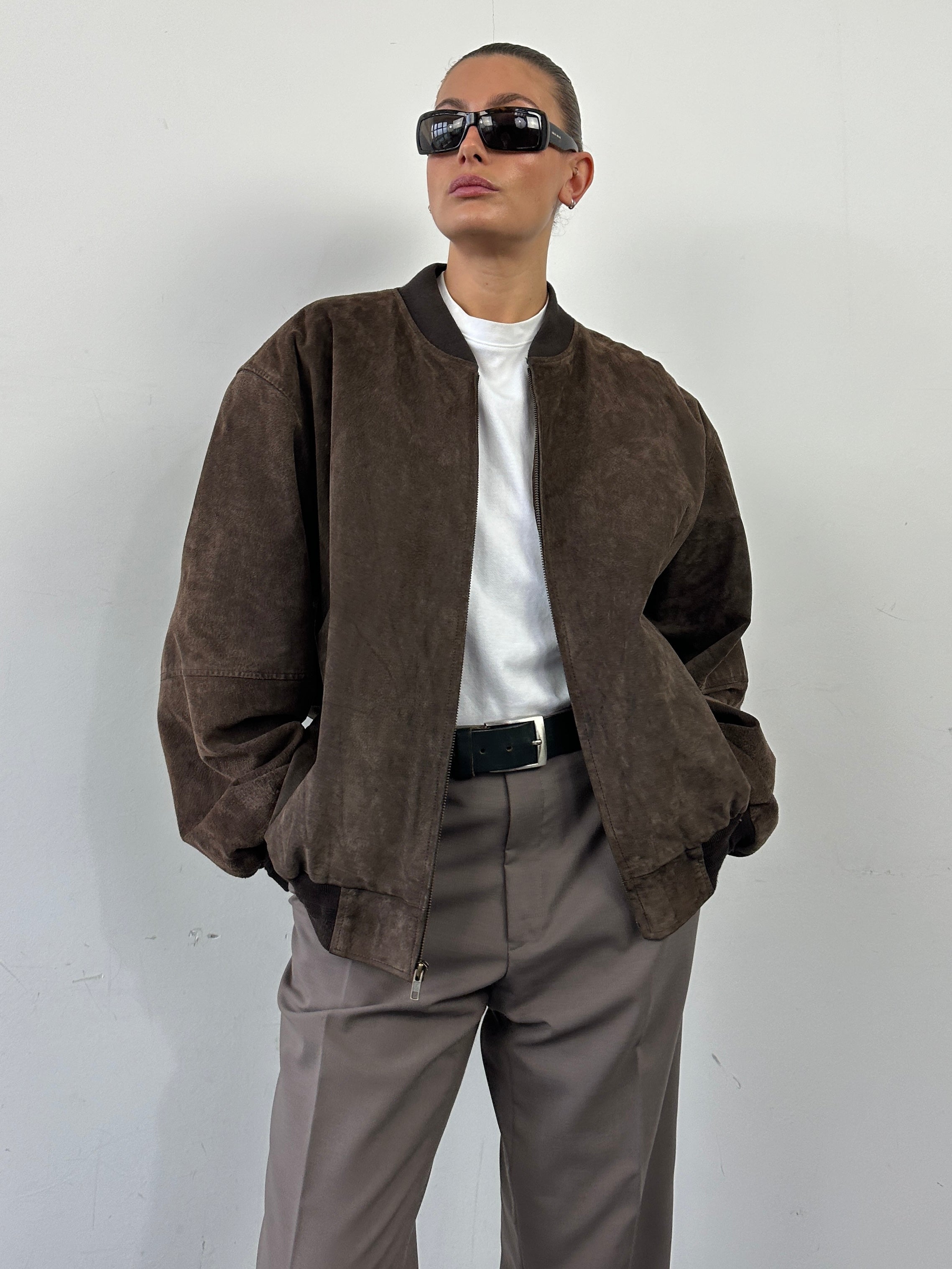 Vintage suede leather bomber jacket in XL, featuring classic design and soft texture, displayed on a hanger.