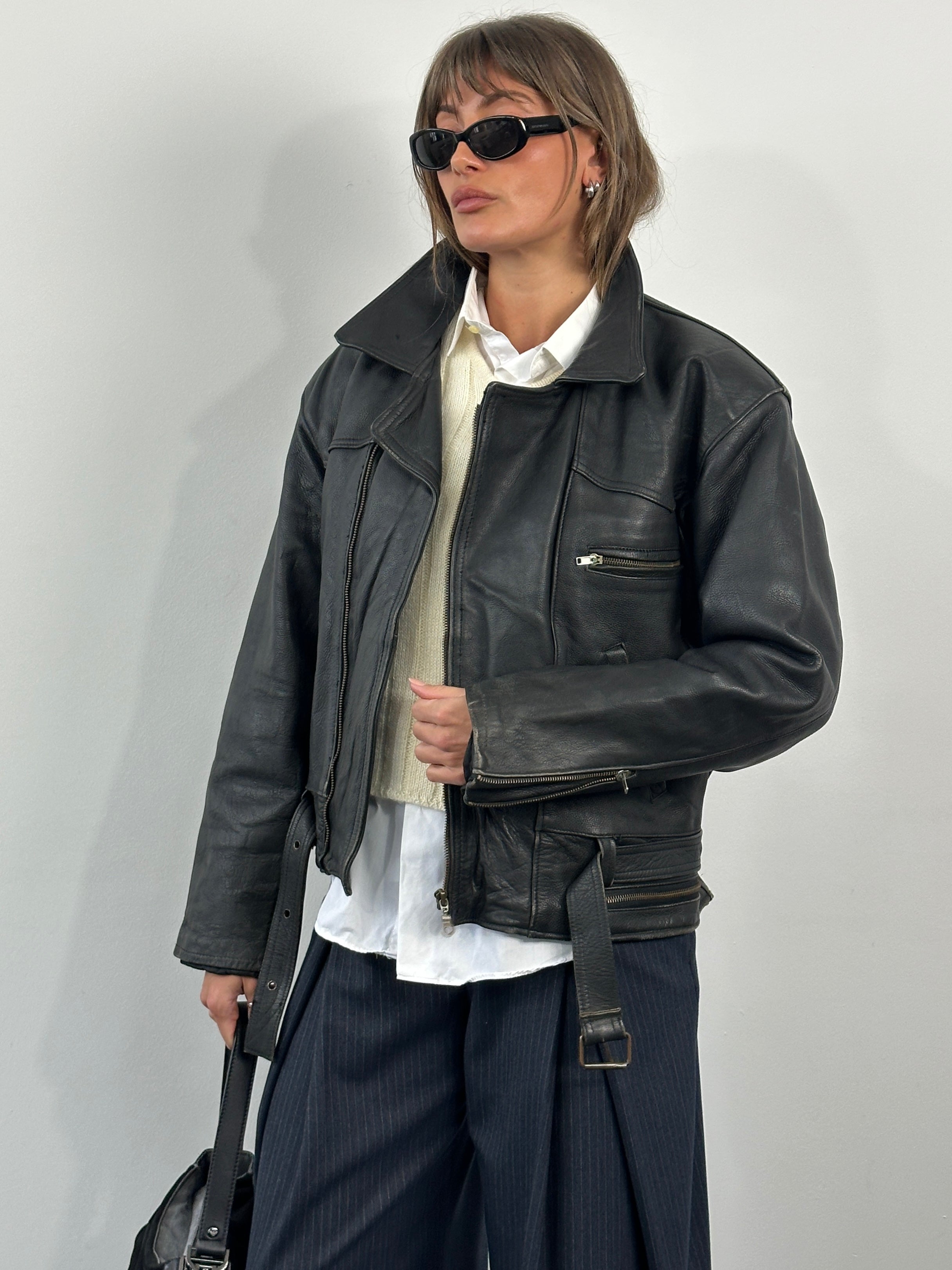 Vintage 1990s leather biker jacket with lapels and metal hardware, black leather, in size M/L.