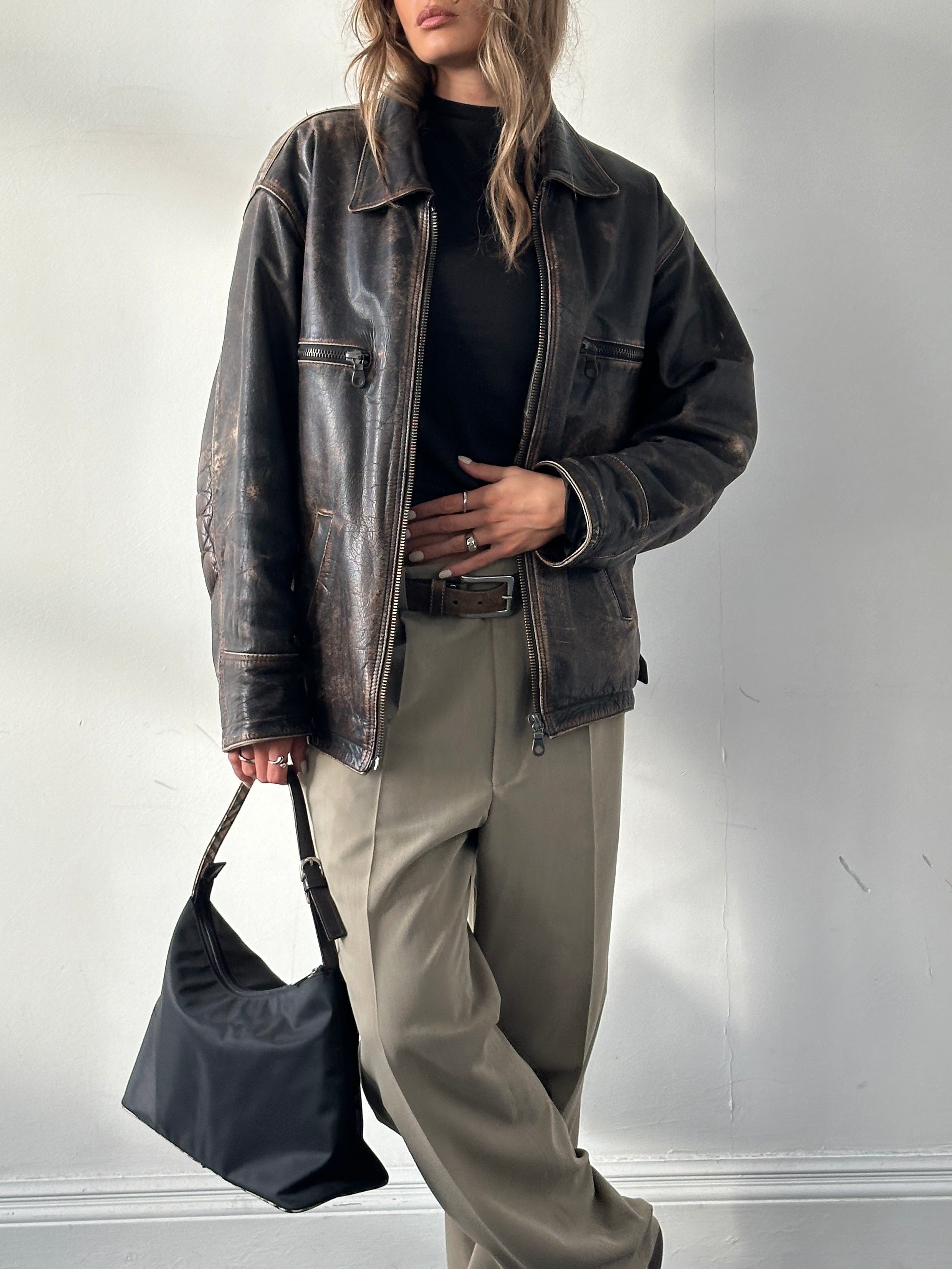 Vintage distressed leather jacket in size M/L with a rugged, worn-in look, featuring classic craftsmanship and vintage style.