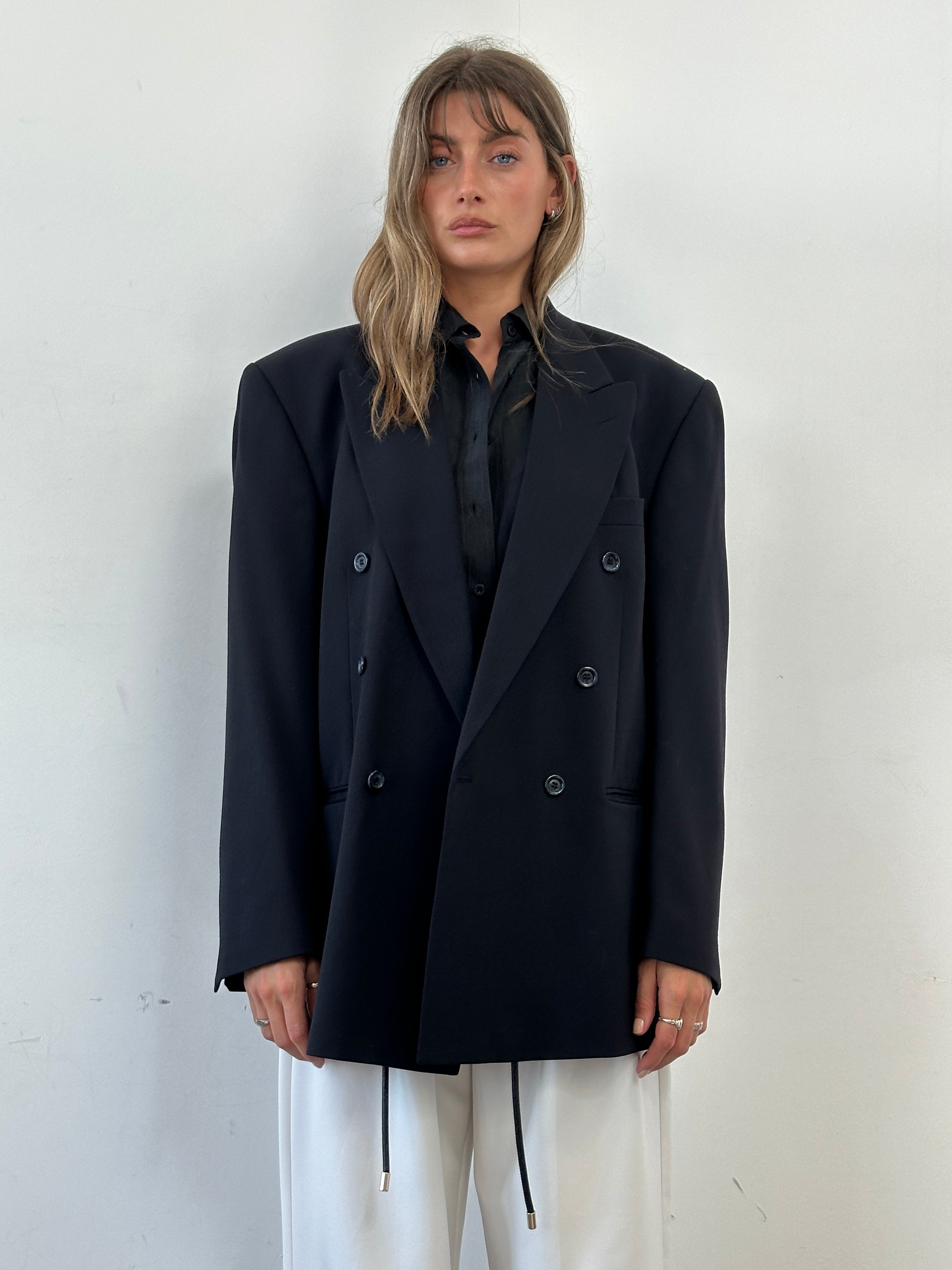 Vintage double-breasted wool blazer in size XL, showing classic tailored fit and textured fabric in a natural setting.