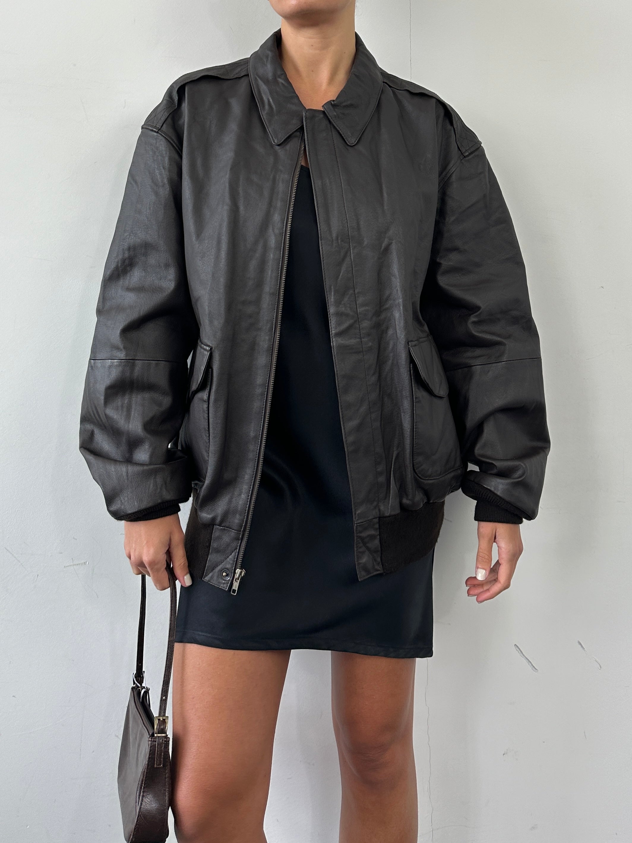Vintage leather bomber jacket in size XL, featuring classic design and rich texture, shown on a hanger.