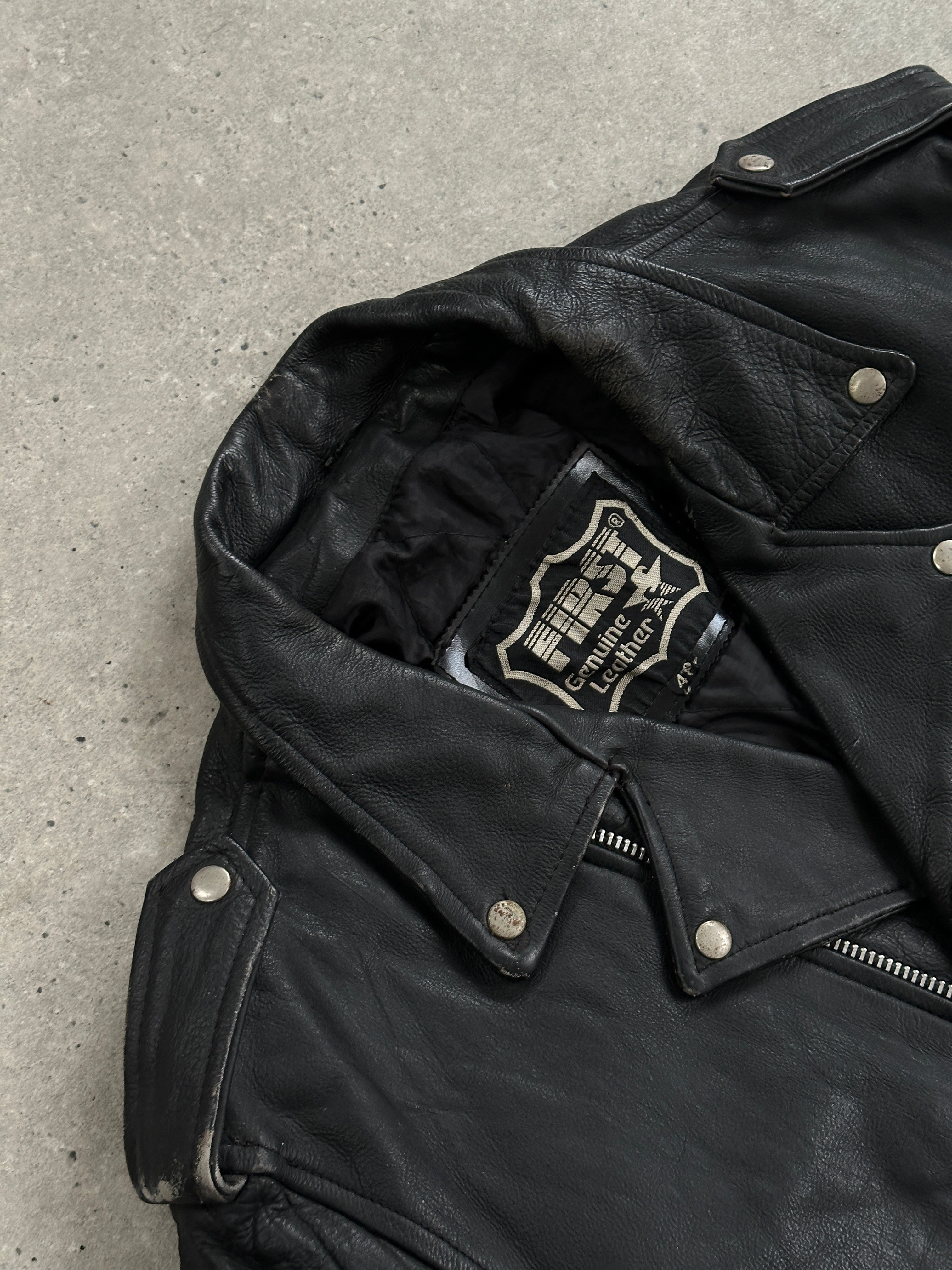 Vintage leather biker jacket in XL, featuring classic design, rugged texture, and silver hardware, perfect for a vintage edgy look.