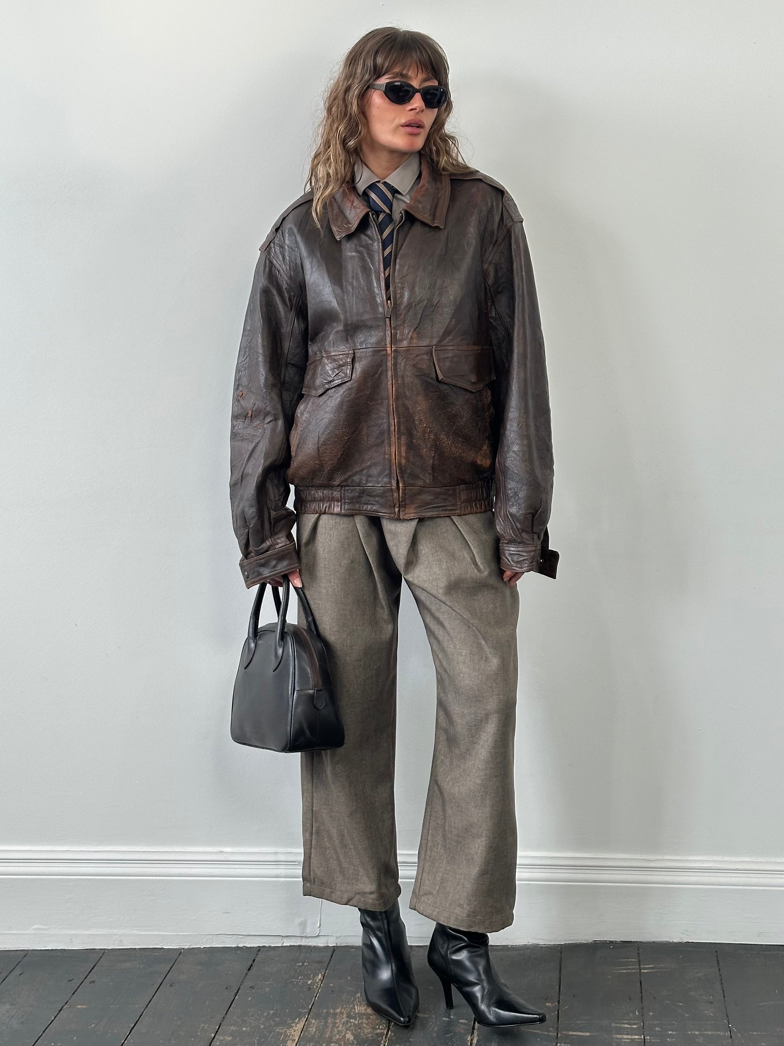 Vintage 1990s distressed leather bomber jacket in XL, featuring rugged texture and classic style.