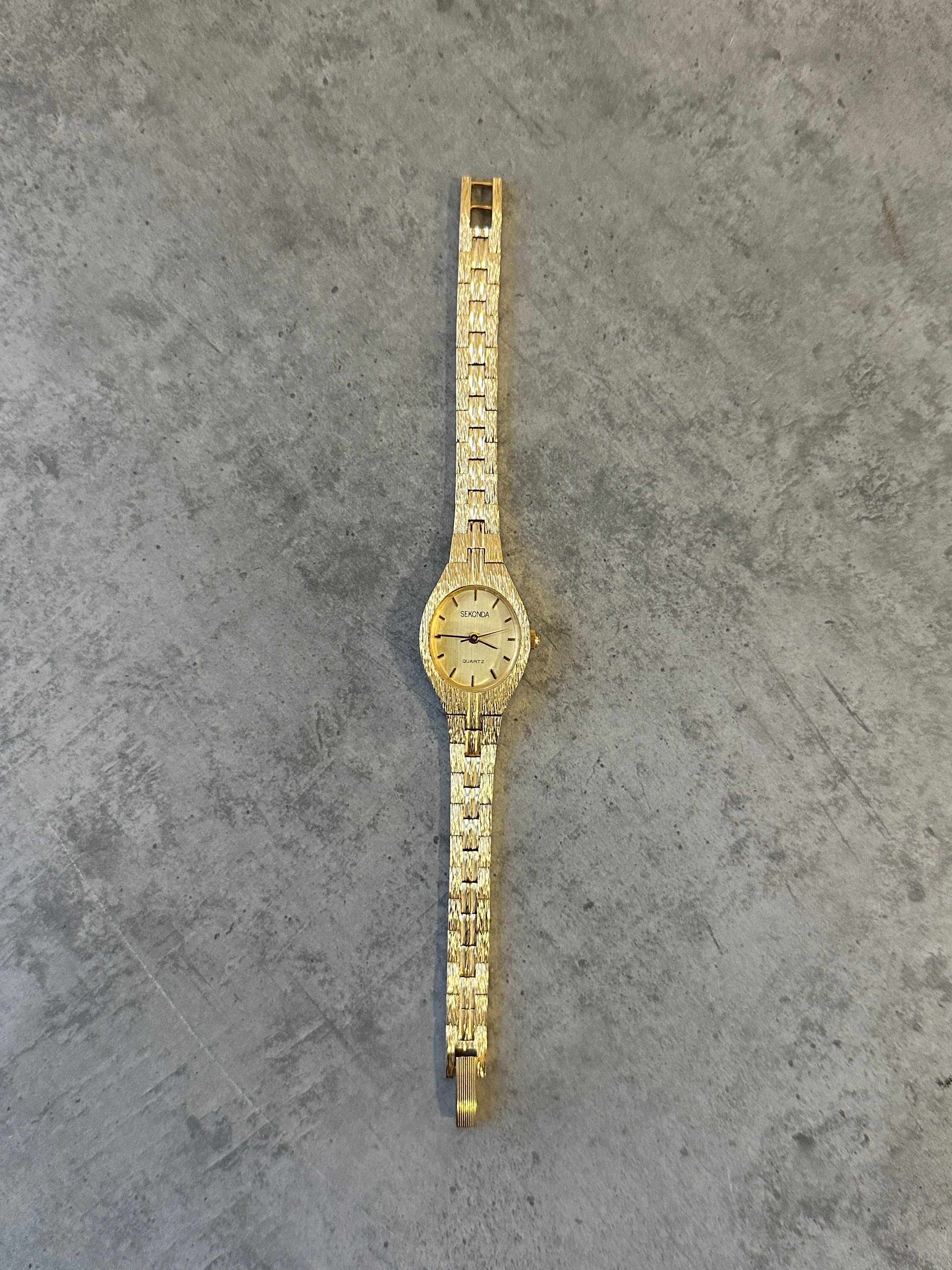 Sekonda 1990s gold-tone quartz watch with a round dial and metal bracelet, vintage style timepiece.
