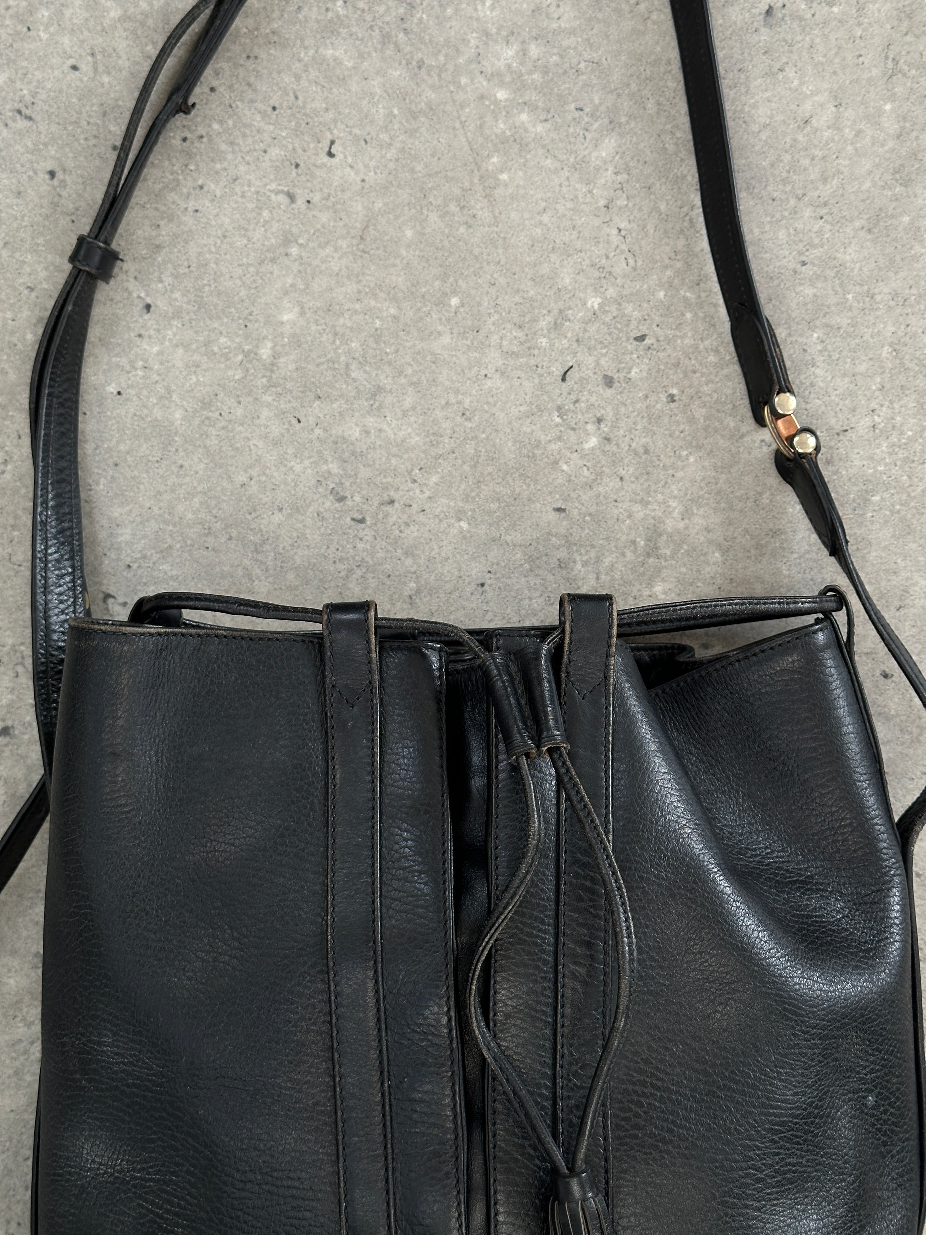 Cartier 1980s leather bucket bag with classic design and gold-tone hardware, featuring adjustable leather strap and spacious interior.
