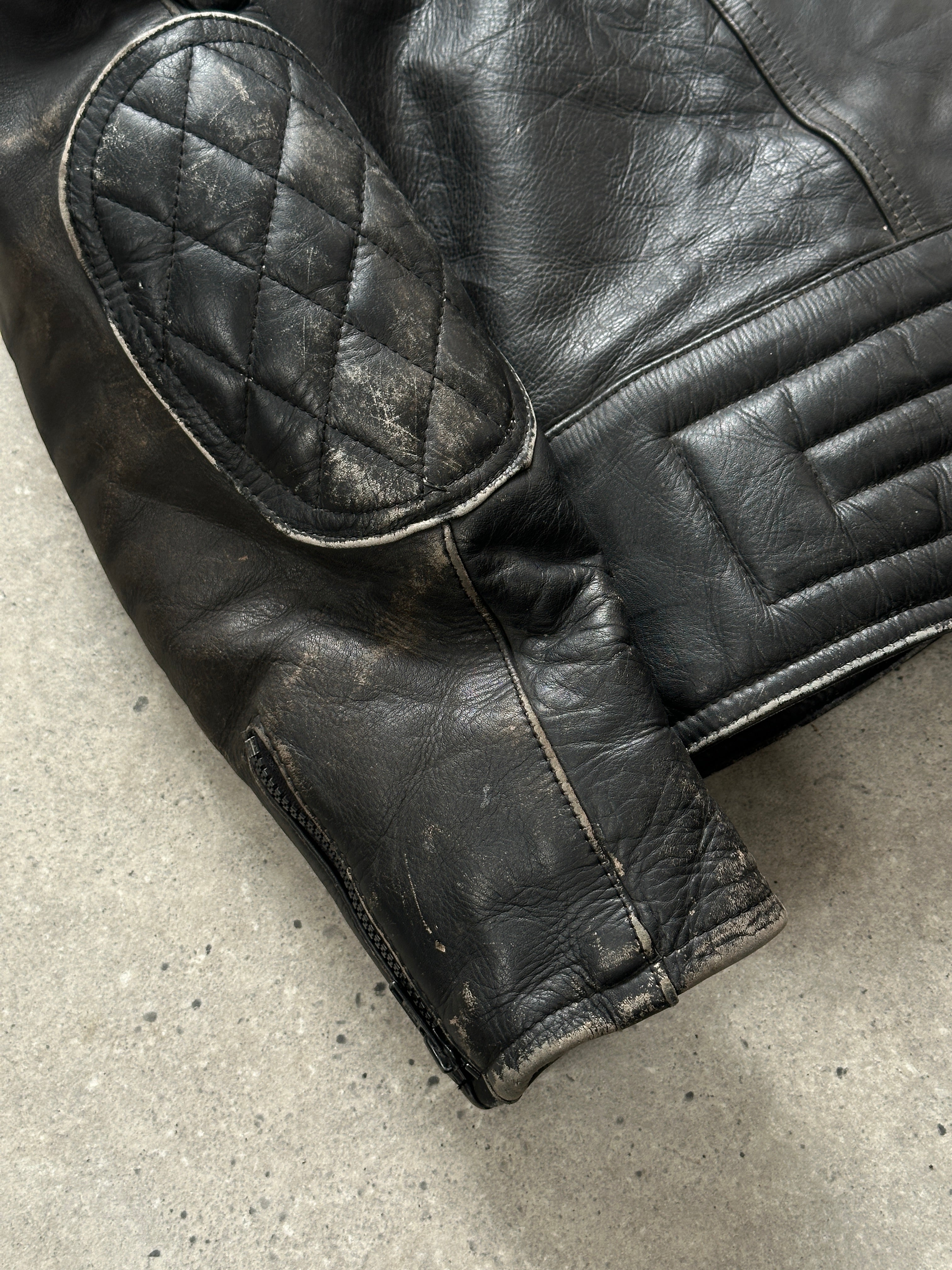 Vintage distressed motorcycle leather jacket in size L/XL, featuring a rugged, worn-in look and classic motorcycle style.