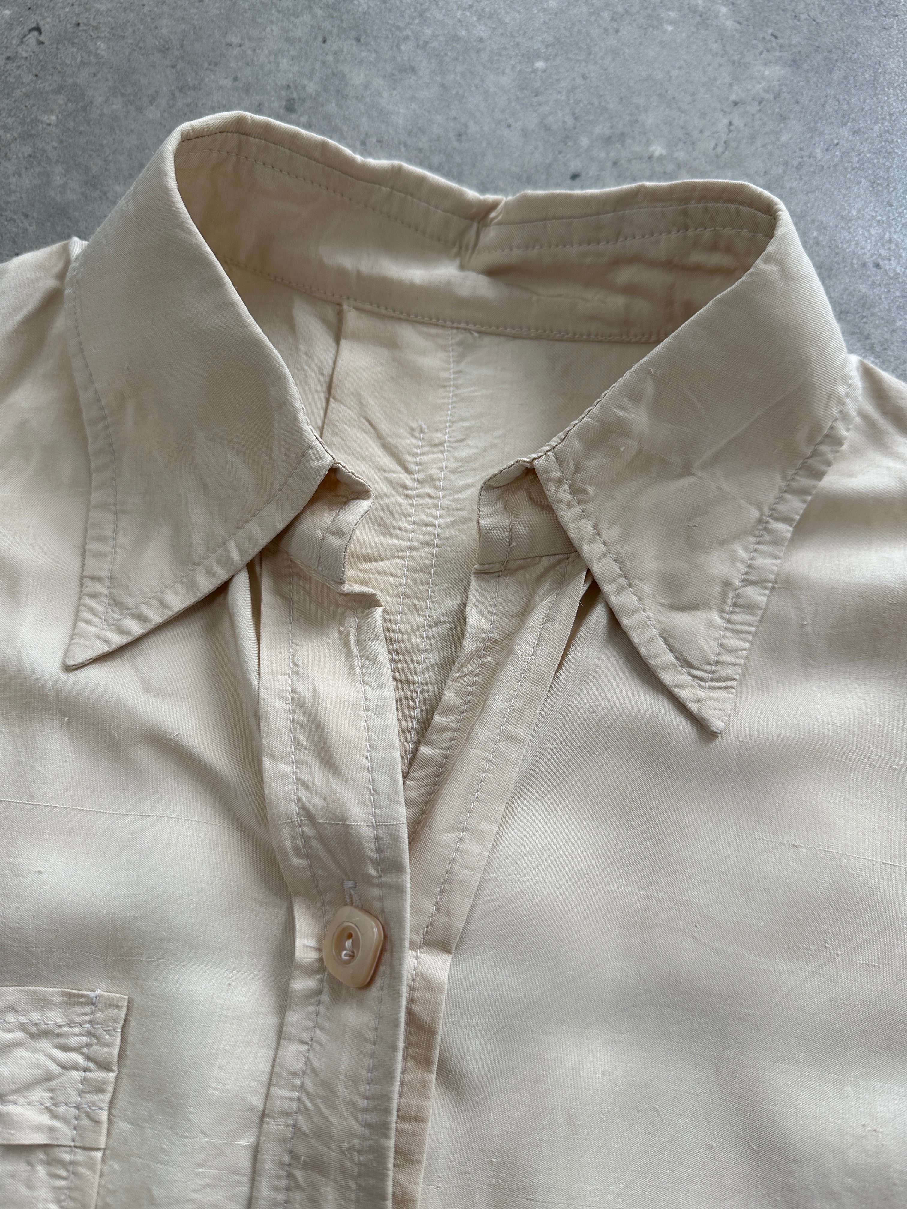 Vintage silk button-up shirt in size small, featuring a classic collar and elegant design, displayed on a hanger.