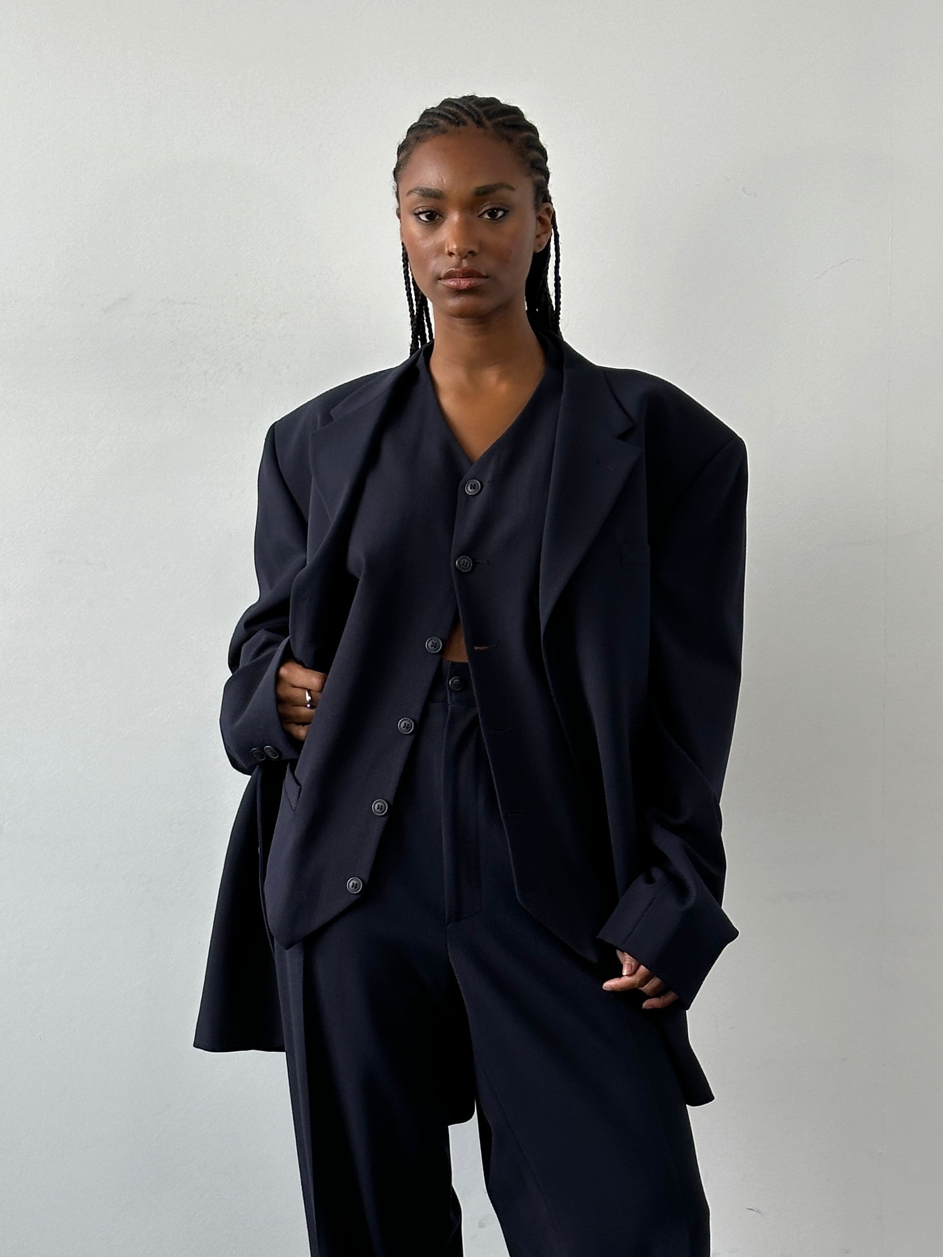 Versace Versus 1990s three-piece suit in size 48R/W32, featuring tailored jacket, vest, and trousers with bold pattern details.