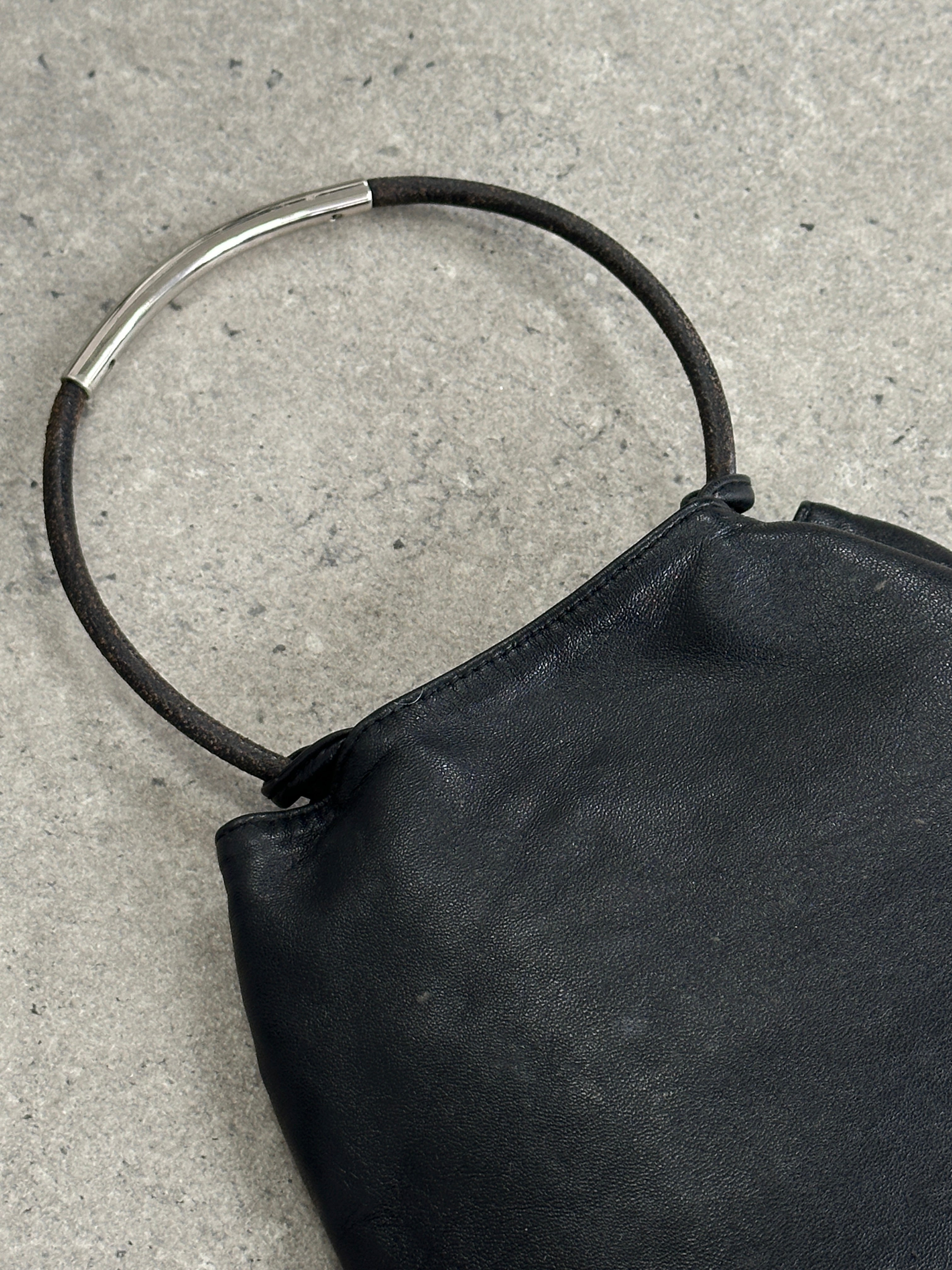 DKNY soft leather clutch bag with sleek design, featuring a smooth leather exterior and compact shape for stylish carrying.