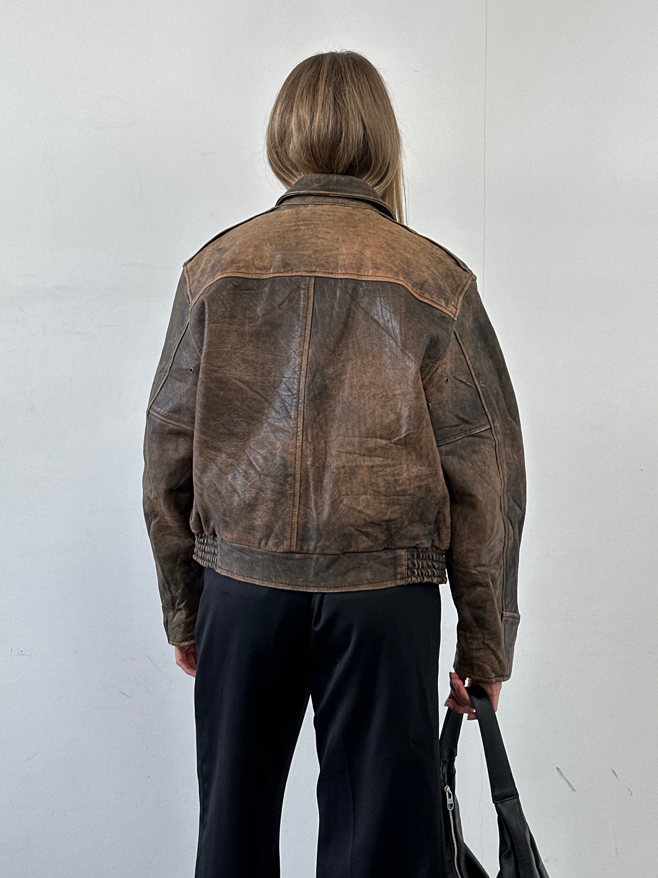 Vintage distressed leather bomber jacket in size M/L, featuring rugged texture and classic design, from the Vintage brand.