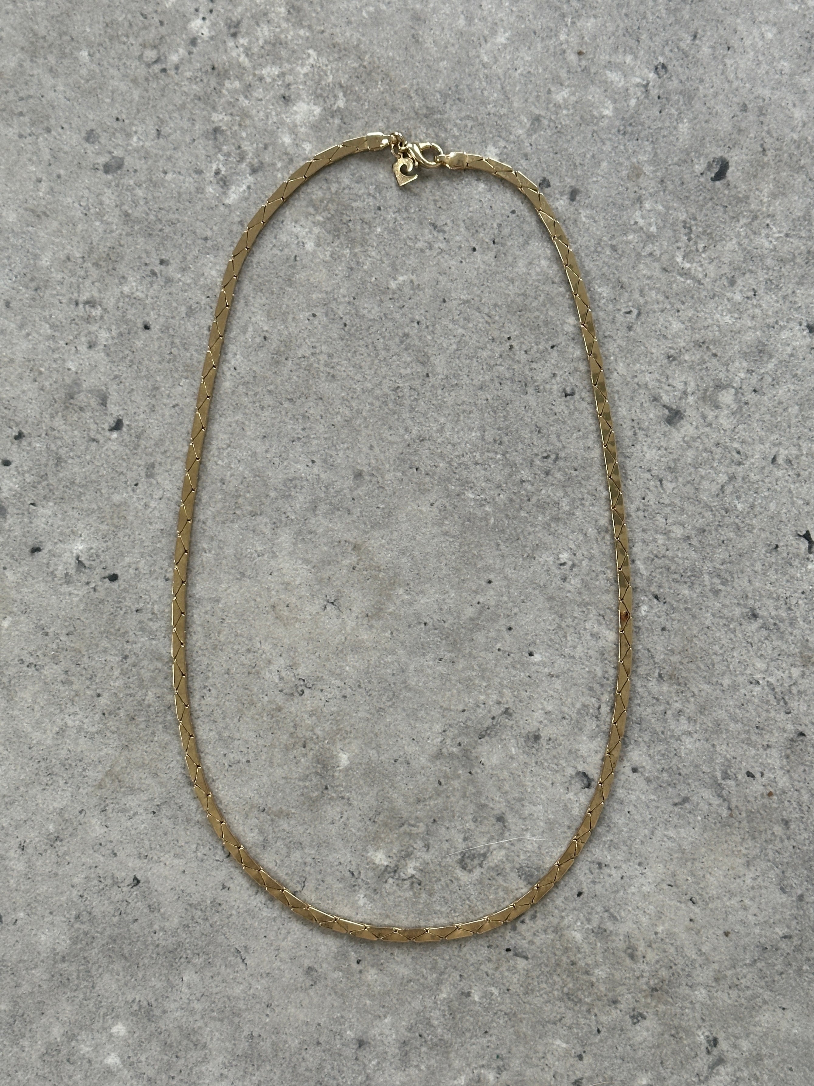Pierre Cardin gold-plated necklace with a sleek chain and subtle pendant, showcasing elegant jewelry design.