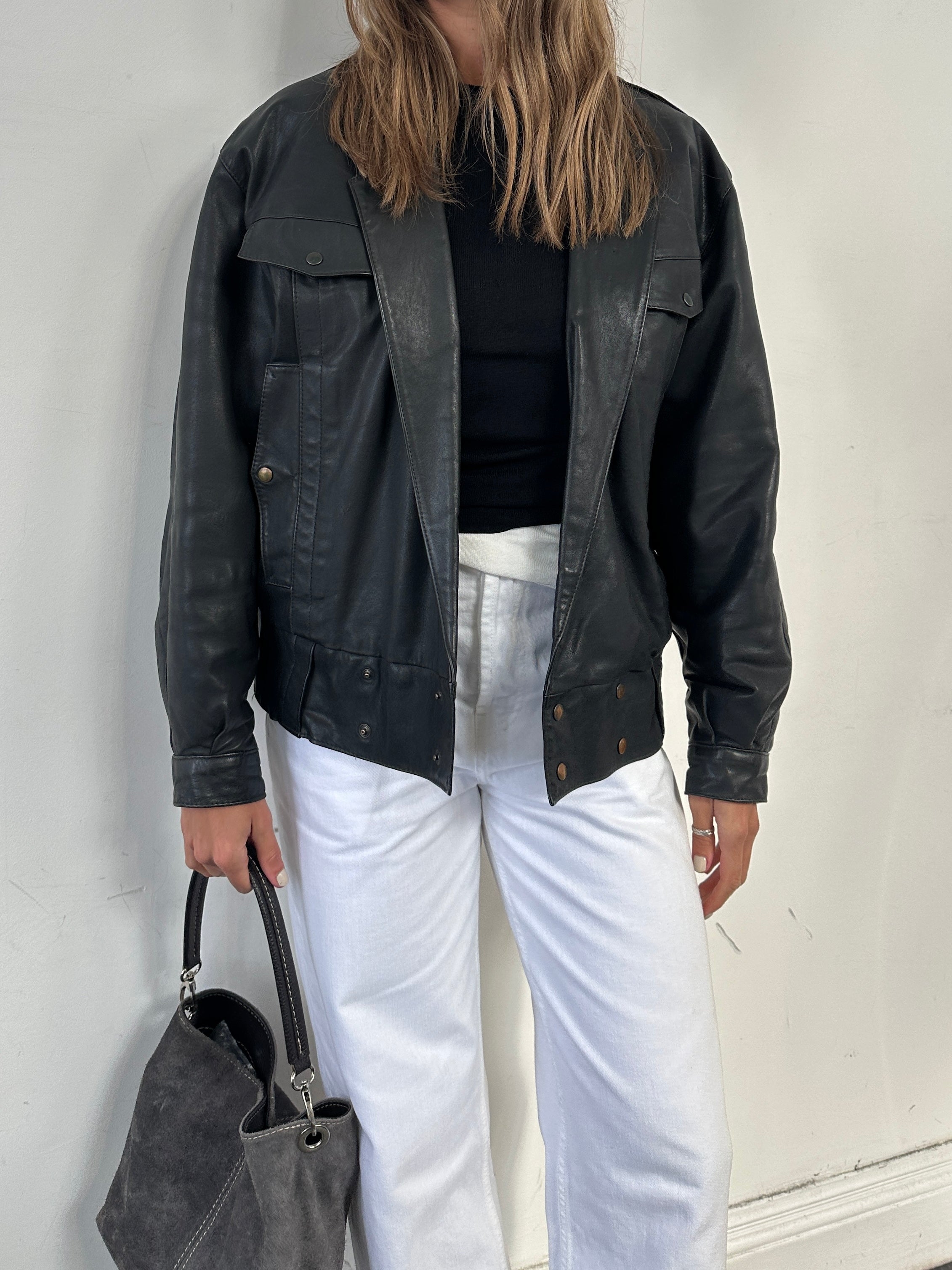 Vintage leather bomber jacket in size small, featuring classic design and detailed stitching, displayed on a hanger.