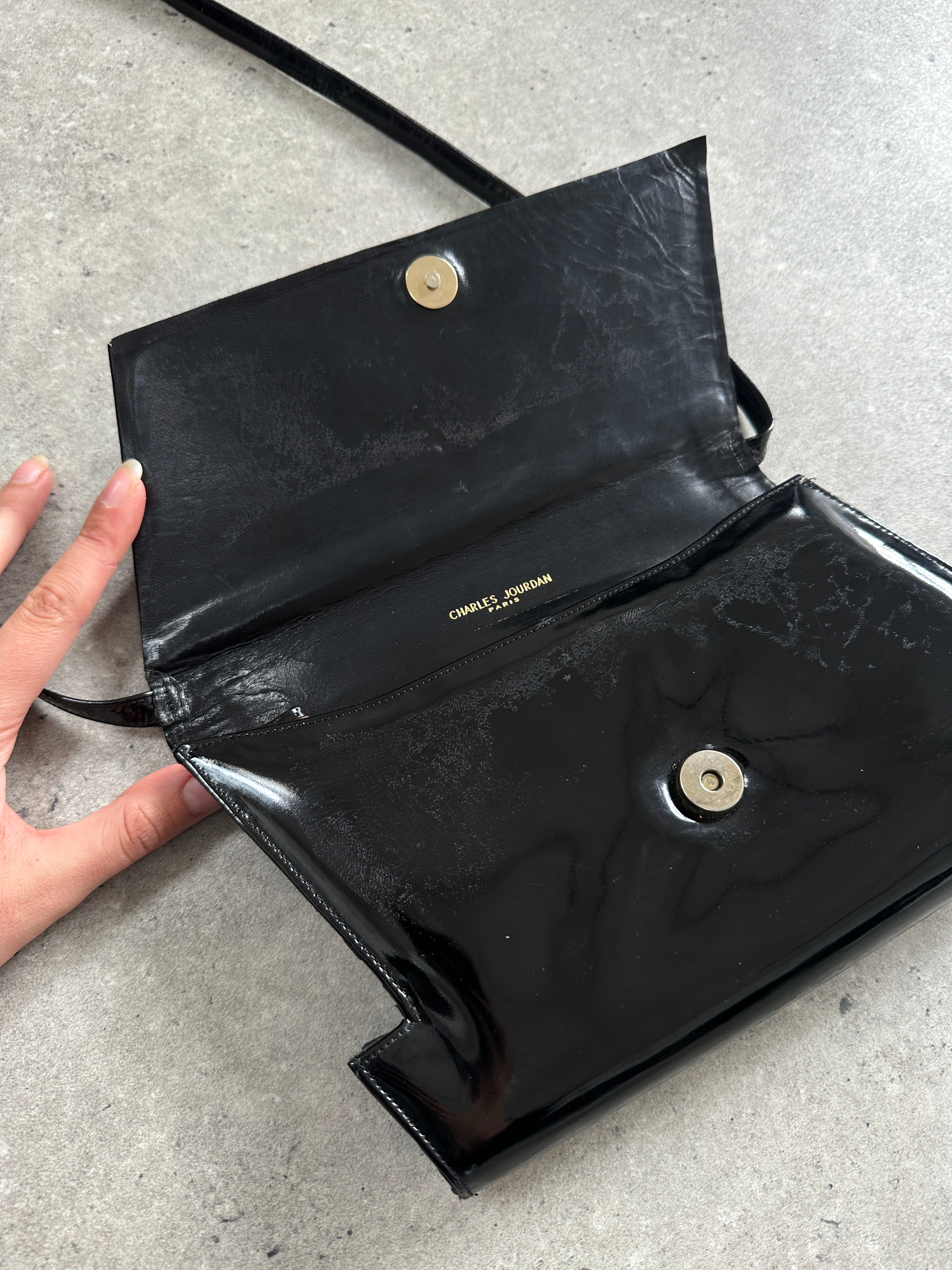 Charles Jourdan 1990s asymmetric patent crossbody bag with sleek design and structured silhouette, featuring a modern, stylish look.