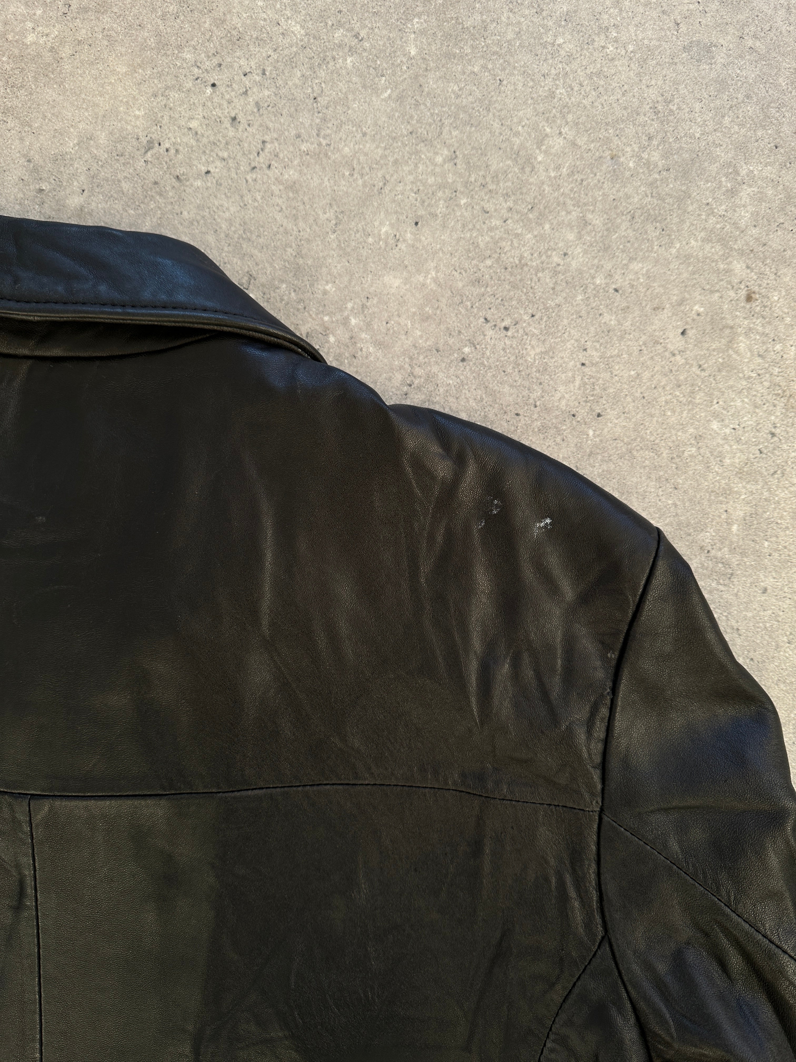 Vintage minimal leather jacket in size M/L, featuring sleek design and classic style, shown on a hanger.