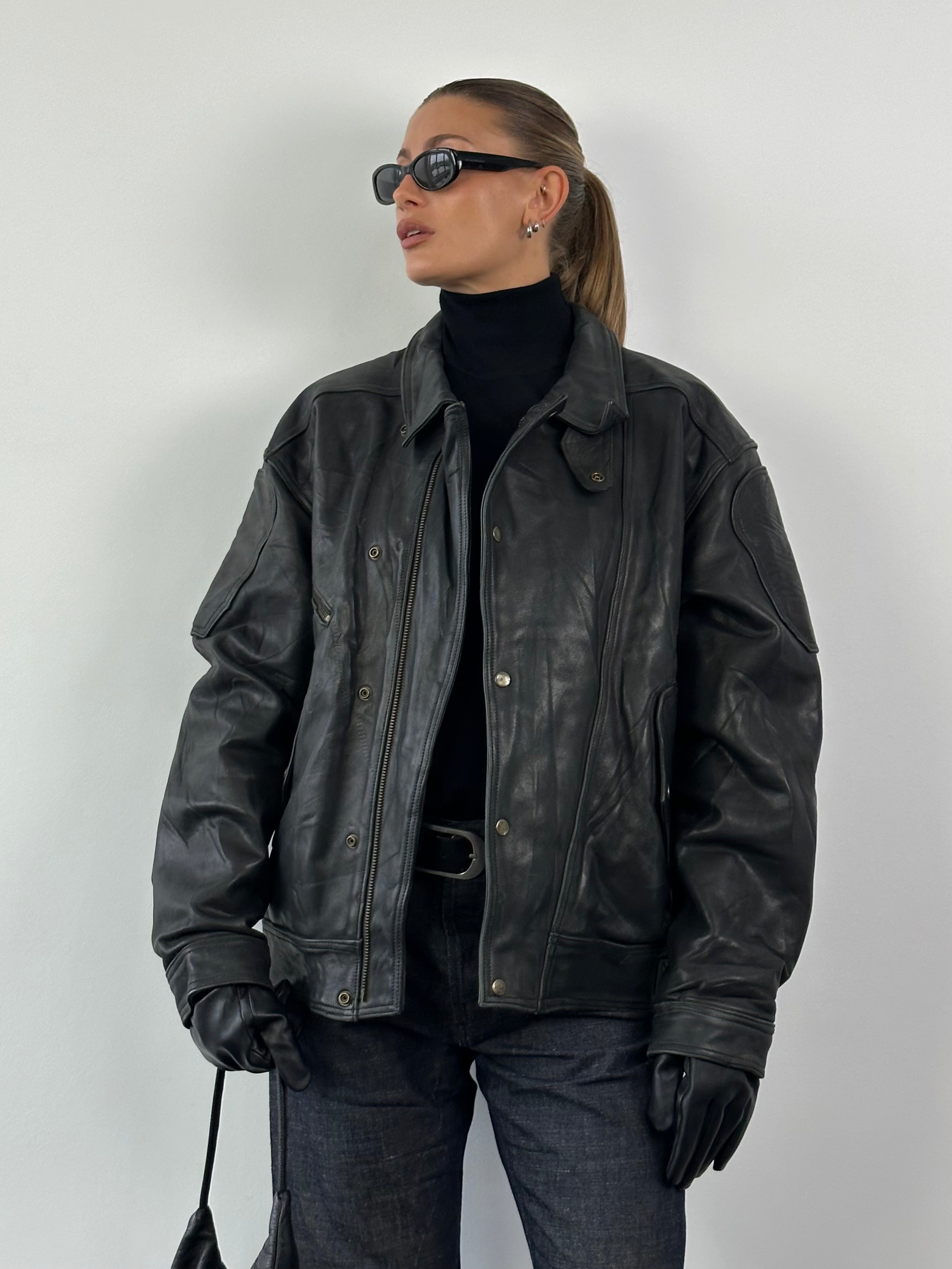 Vintage leather jacket in XL size, showcasing classic design with a worn-in, rugged texture and detailed stitching.