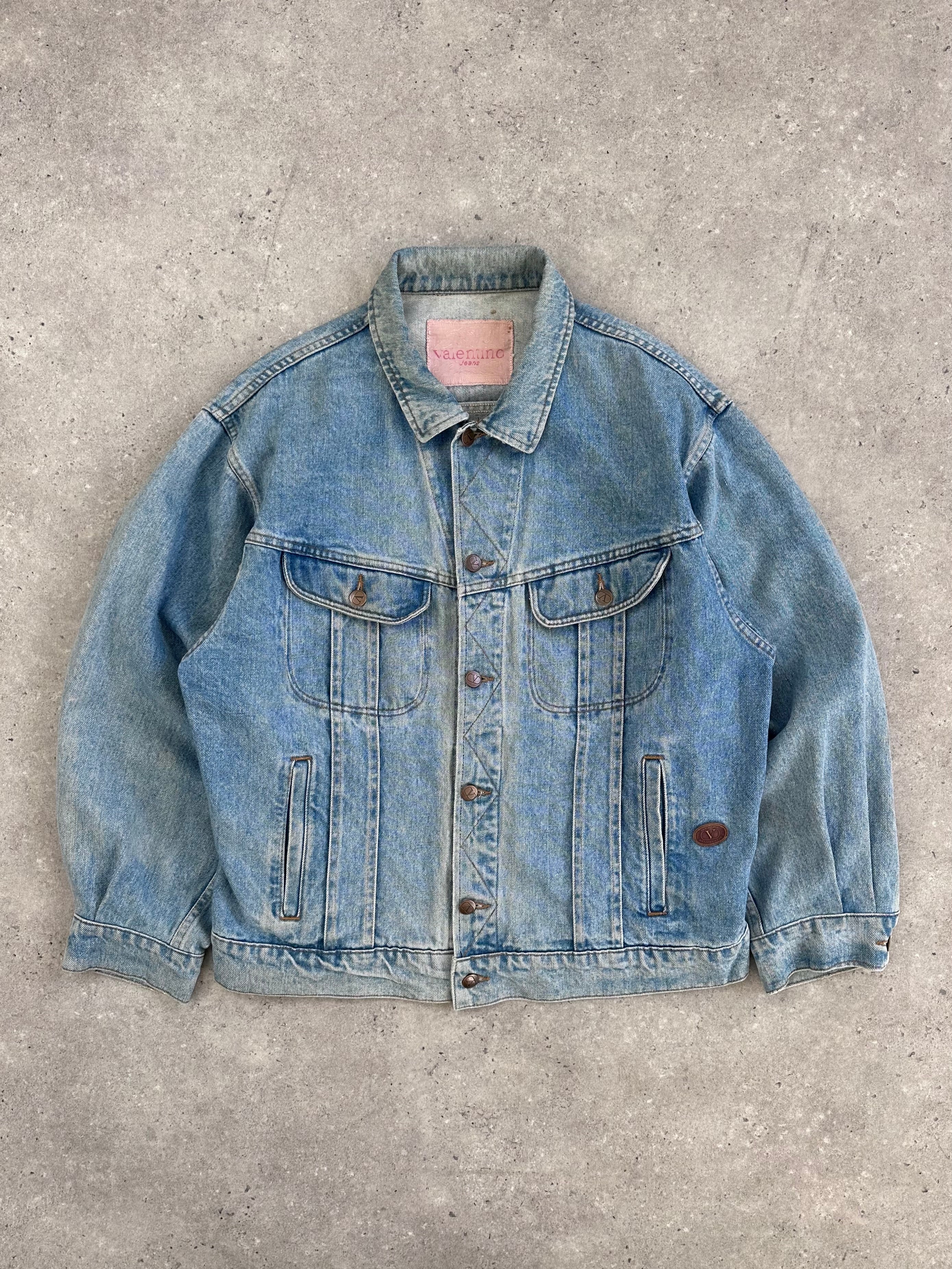 Valentino XL denim jacket with classic blue wash, button-front, and structured collar, displayed on a hanger.
