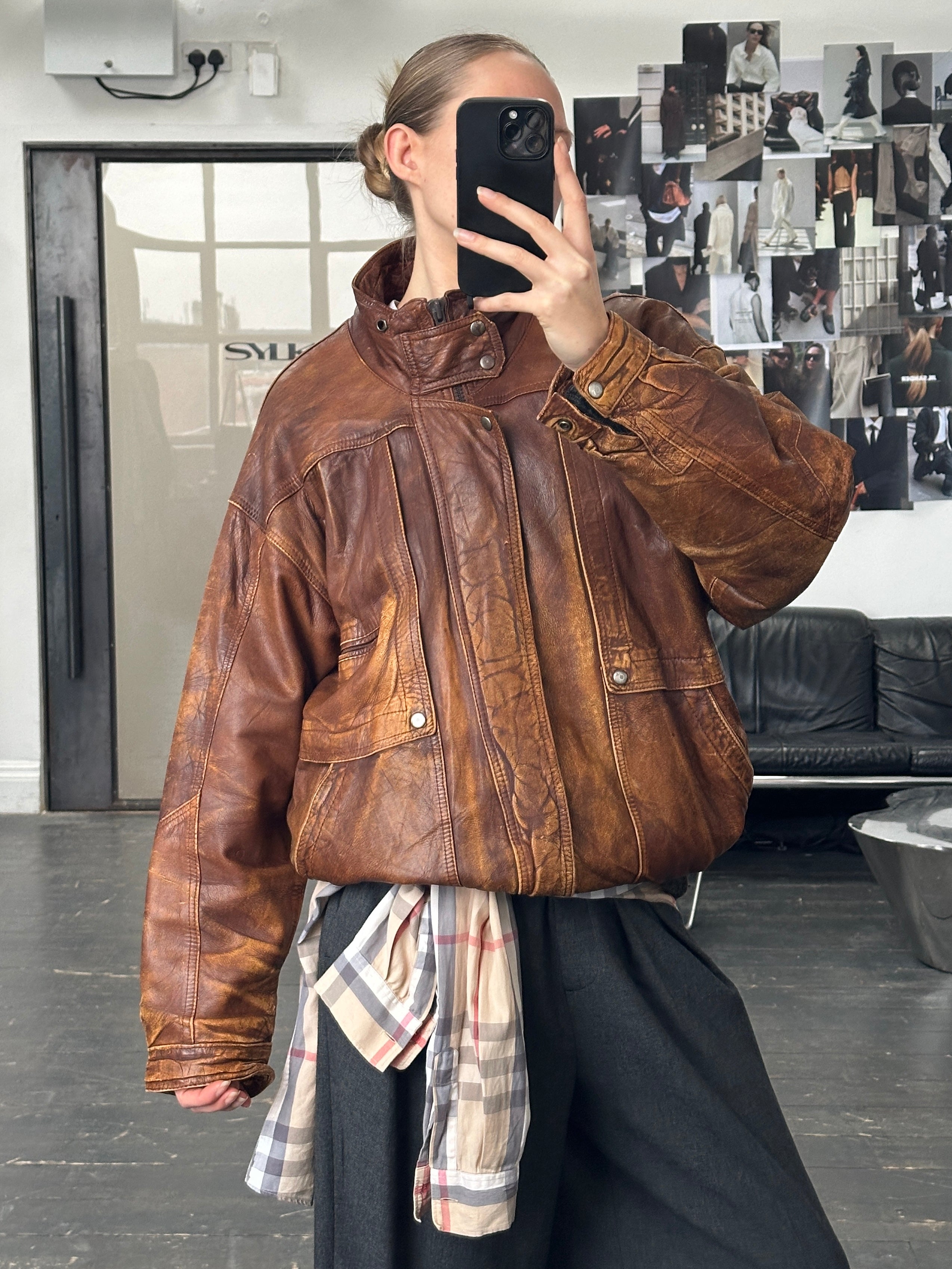 Vintage 1990s aged leather bomber jacket in XL size, showcasing distressed brown leather with ribbed cuffs and collar.