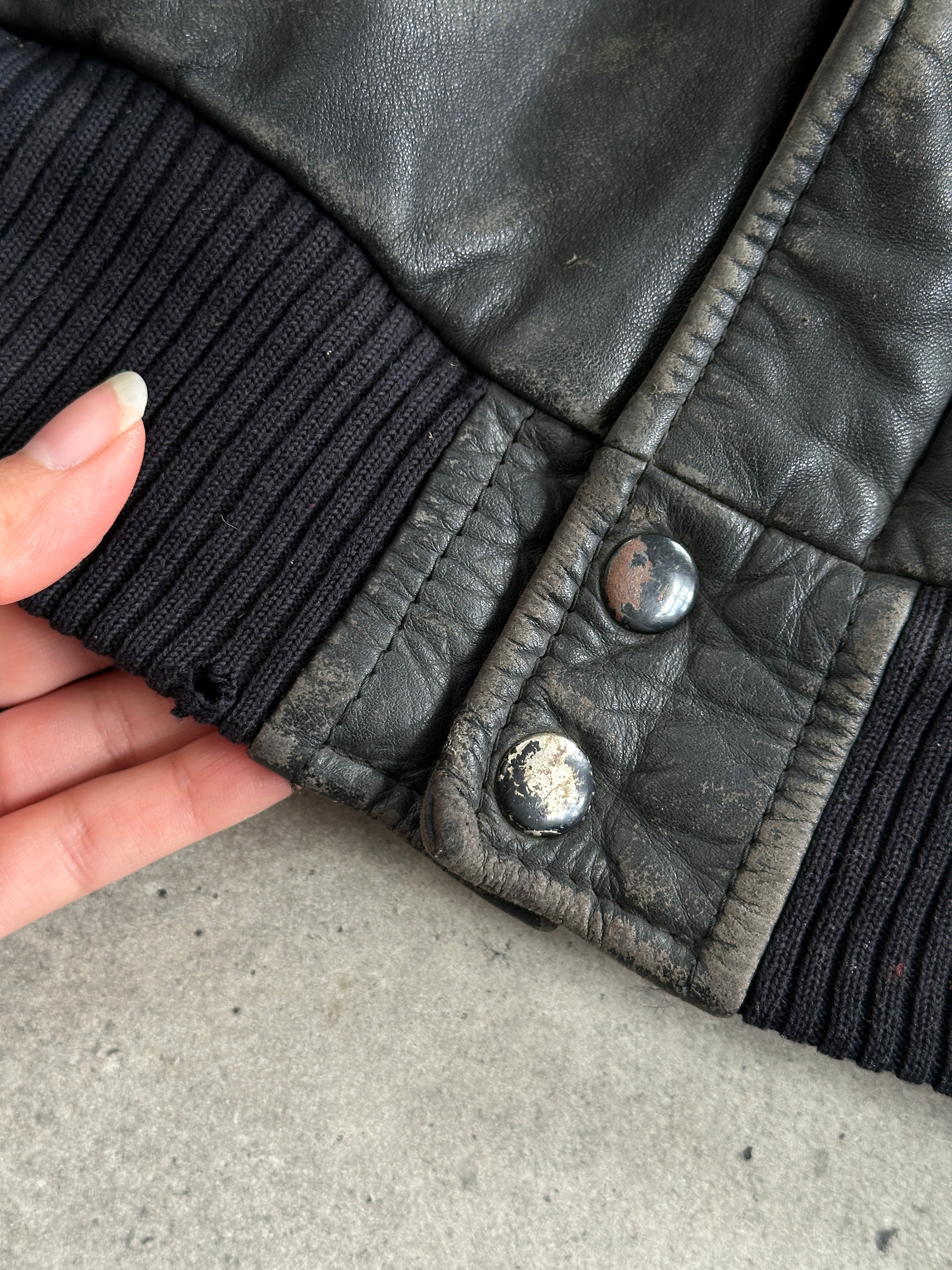 Vintage distressed leather bomber jacket in size M/L, featuring rugged design and classic style.