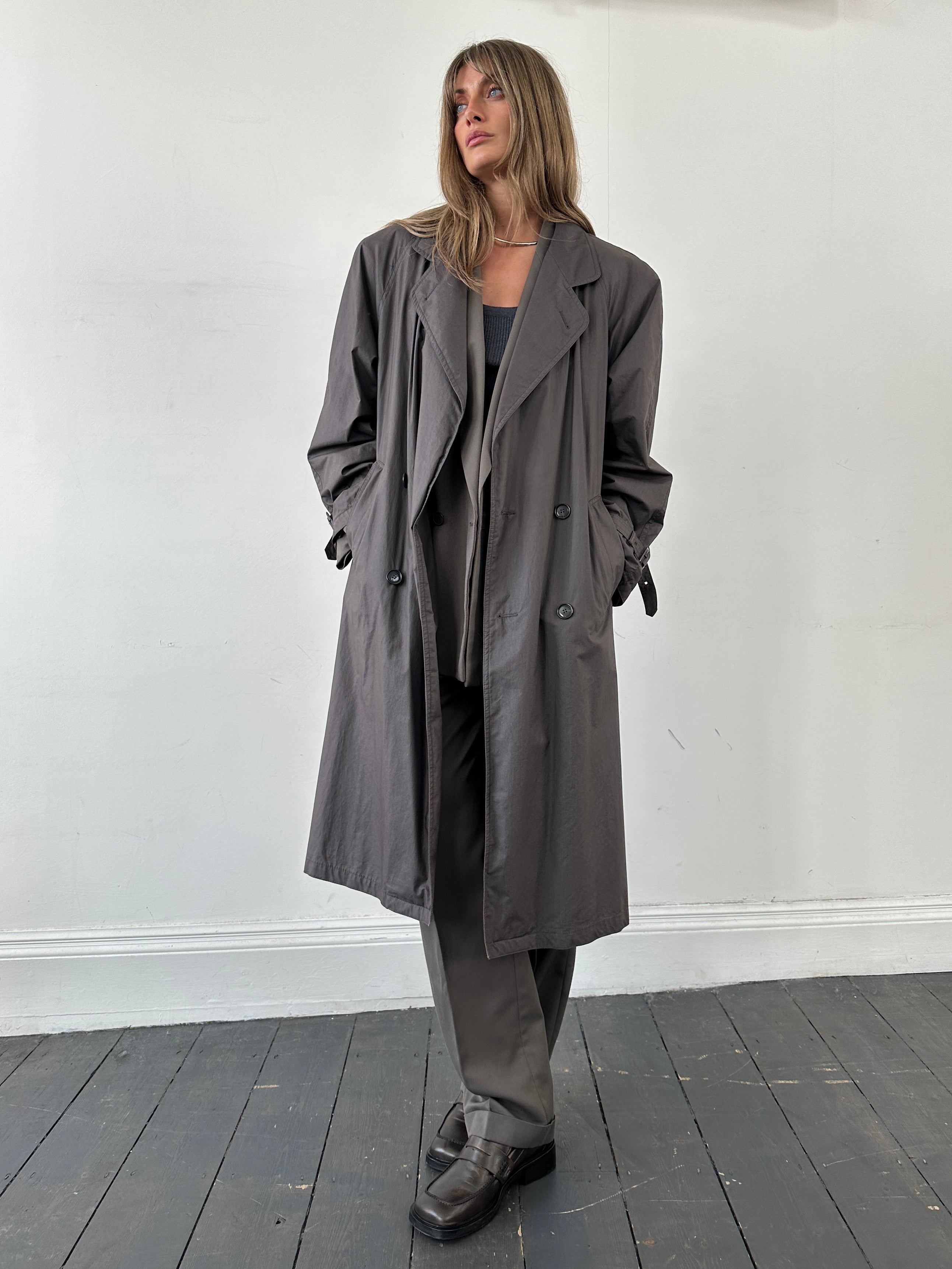 Vintage double-breasted unlined belted trench coat in size large, featuring classic lapels and tailored fit.