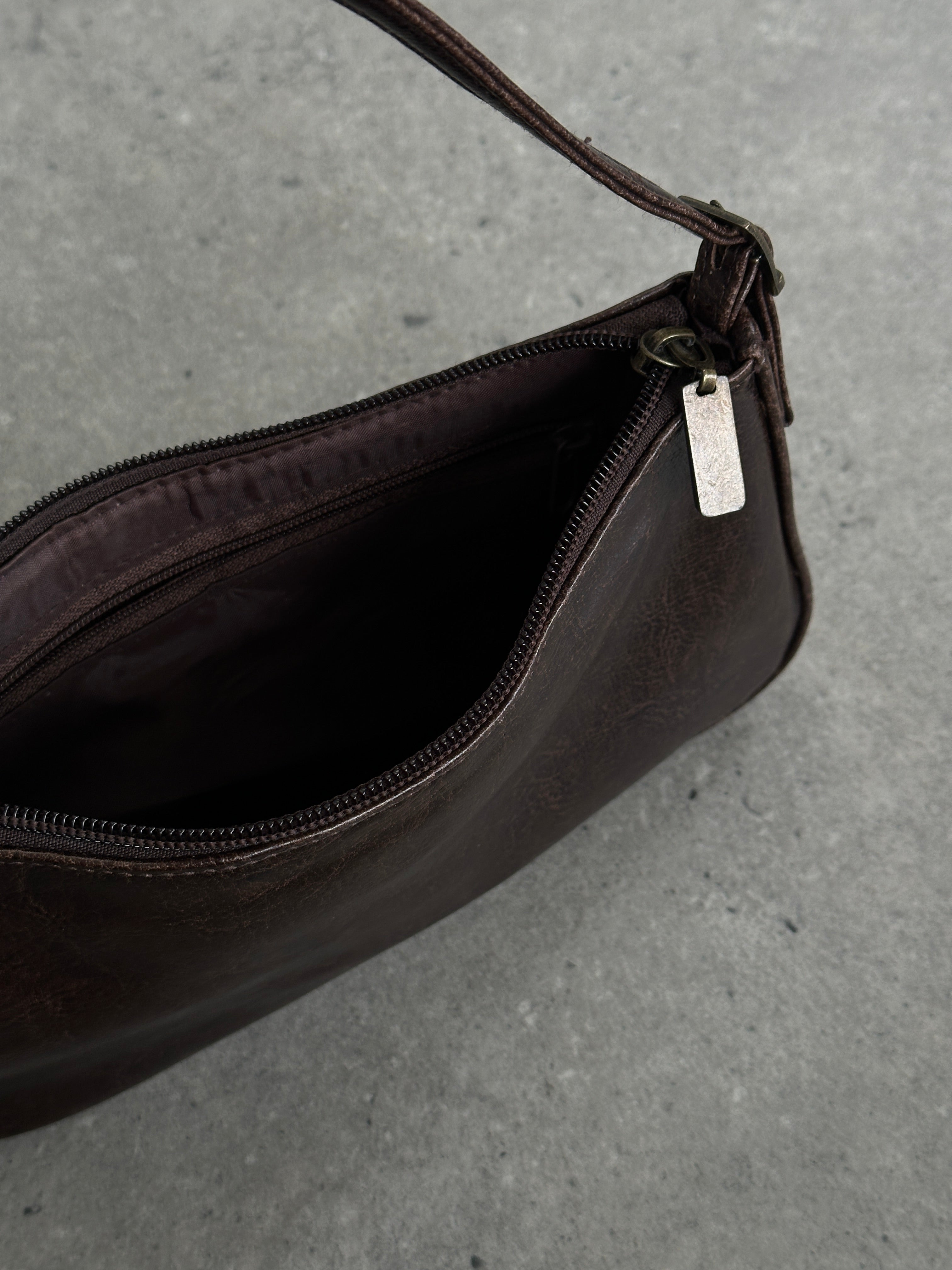 Vintage faux leather shoulder bag with adjustable strap and classic design, showcasing a stylish and versatile accessory.