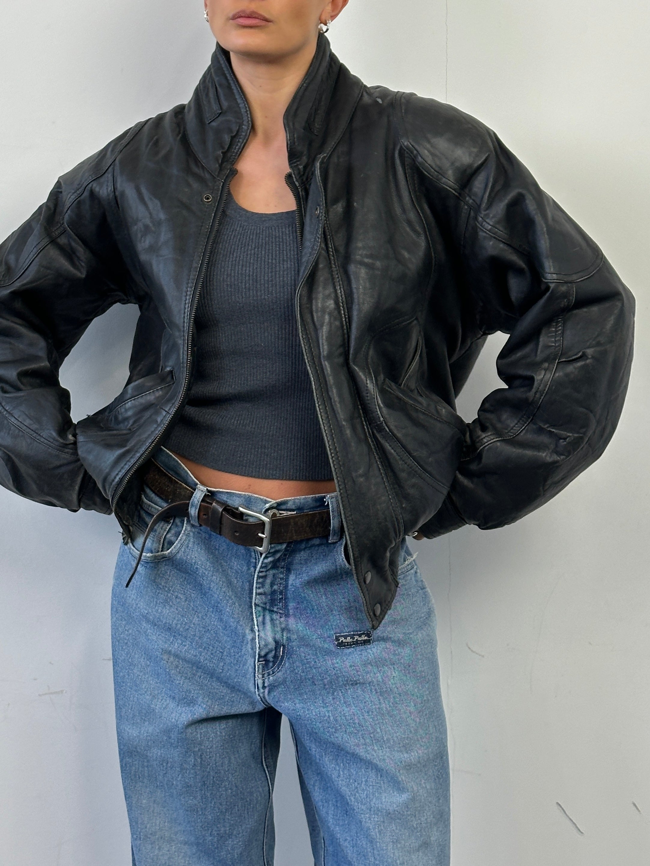 Vintage leather bomber jacket in size M, featuring classic design with a smooth leather finish and ribbed cuffs and collar.