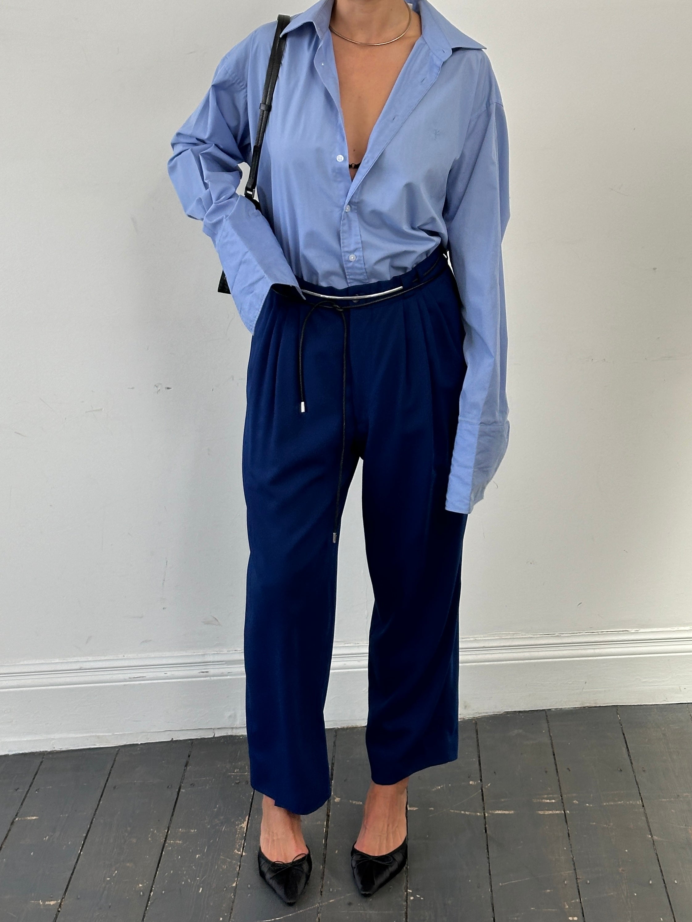 Versace Classic V2 wool pleated high-waisted tailored trousers in navy, displayed on a model with front view.