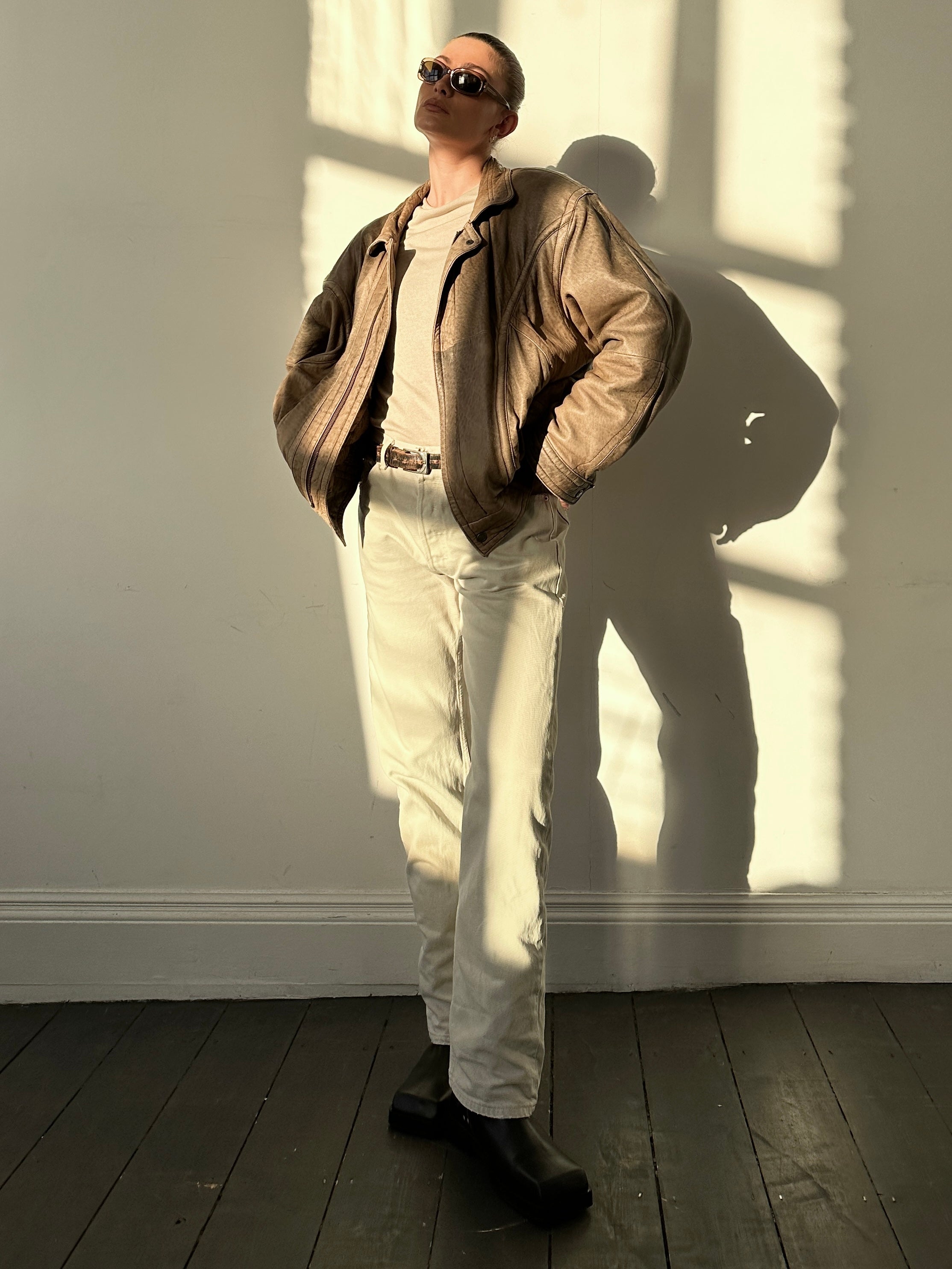 Vintage leather bomber jacket in size L/XL, featuring classic design with a worn-in leather finish and ribbed cuffs.
